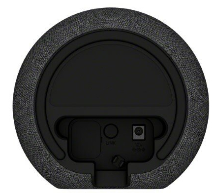 Czarny tył głośnika z szarą tkaniną. Posiada port zasilania, przycisk link i przełącznik. Okrągły design.