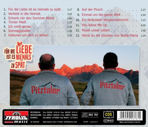 Zwei Männer mit Rücken zur Kamera tragen Sweatshirts mit "Pitztaler"-Aufdruck vor Bergkulisse.