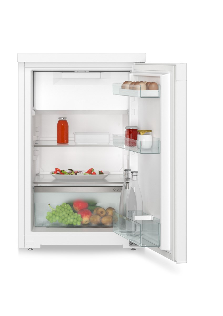 Ein weißer Kühlschrank mit offener Tür, zeigt Regale mit Lebensmitteln, darunter Obst und Getränke.
