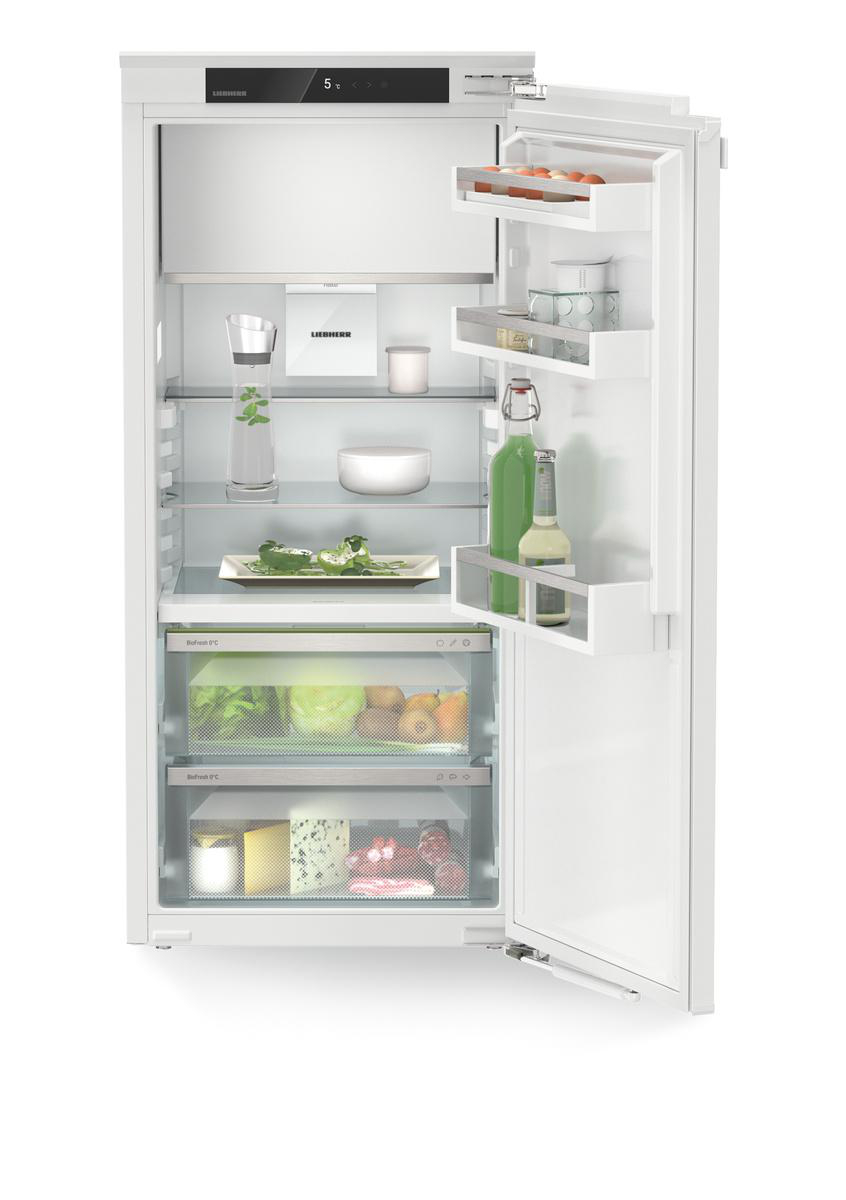 Ein weißer Kühlschrank mit offener Tür, die Regale mit Lebensmitteln und Getränken zeigt.