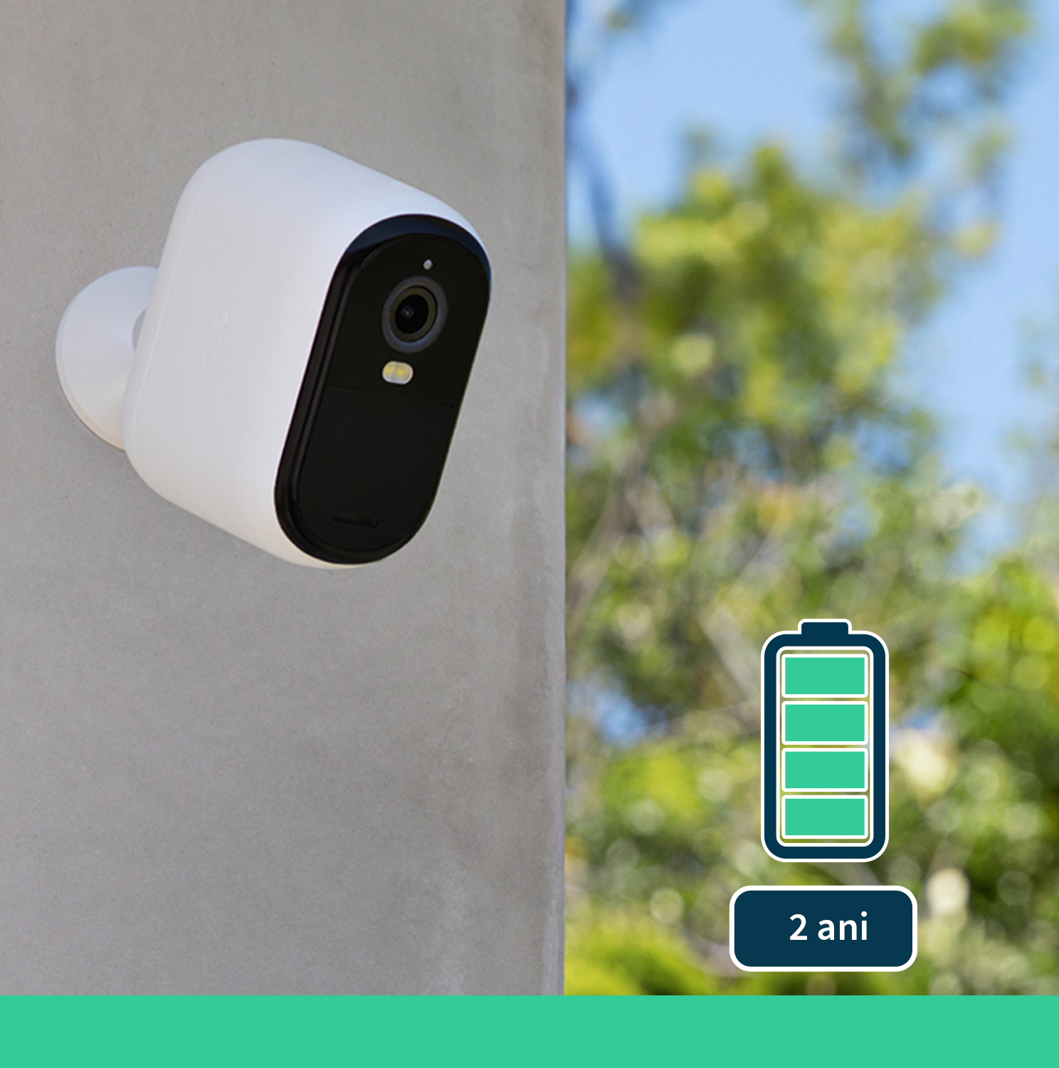 Telecamera di sicurezza bianca montata su muro in cemento con icona batteria verde.