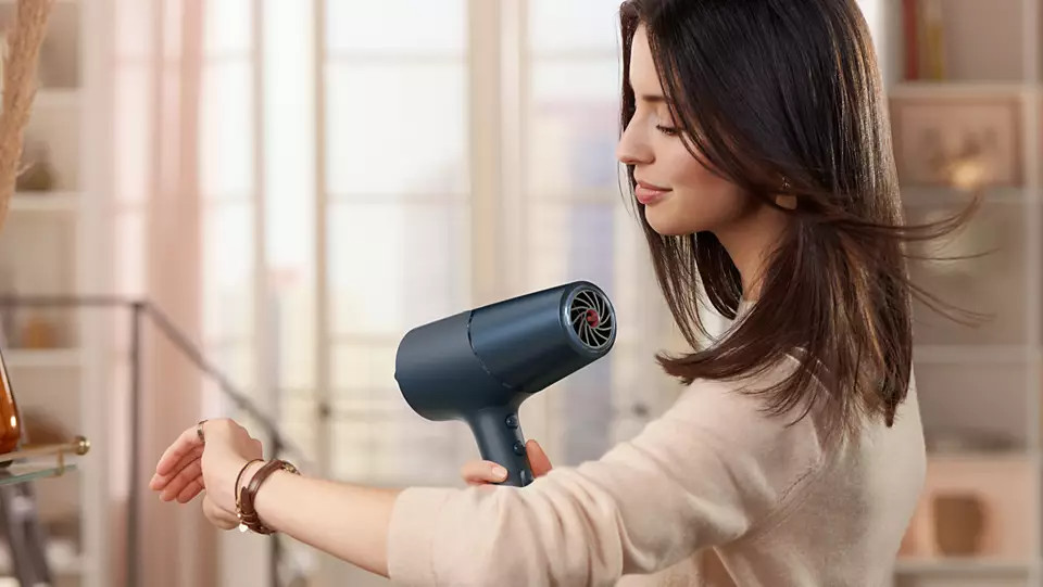 Woman using a blue hair dryer.