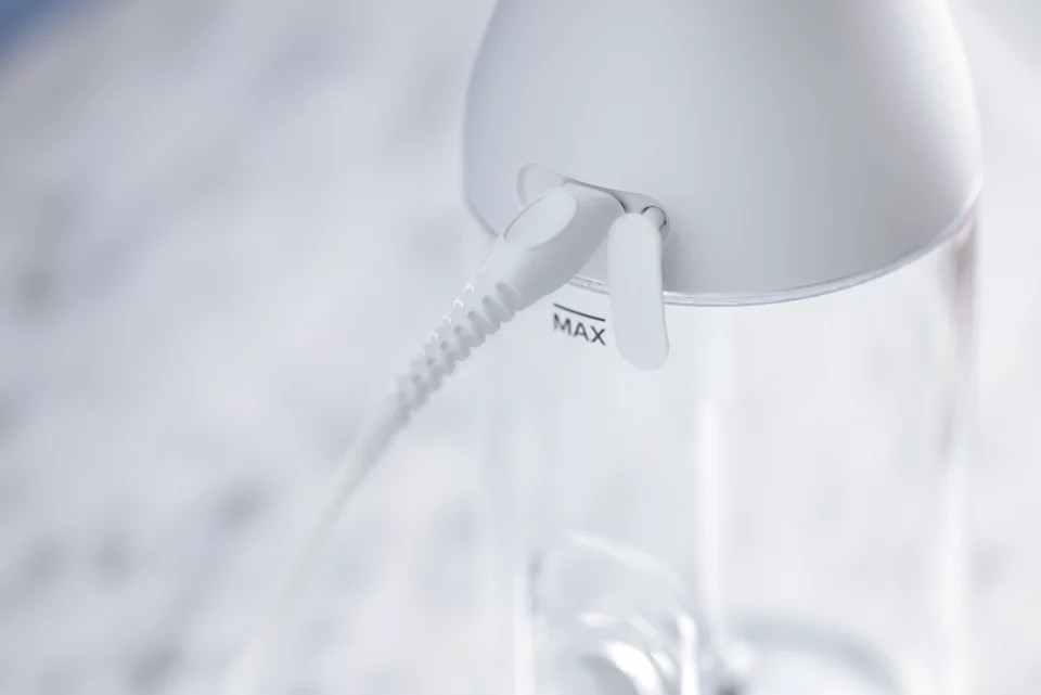 Close-up of a white appliance with a power cord. 