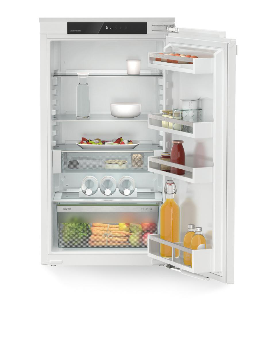 Weißer Kühlschrank mit offener Tür. Regale mit Lebensmitteln: Salat, Getränke und Gemüse. Gut beleuchtet.