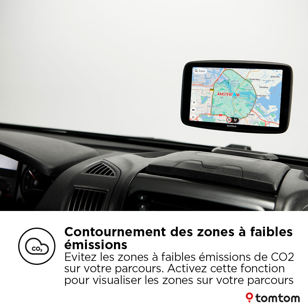 Un appareil TomTom dans une voiture affiche une carte avec navigation, texte sur les zones d'émission.
