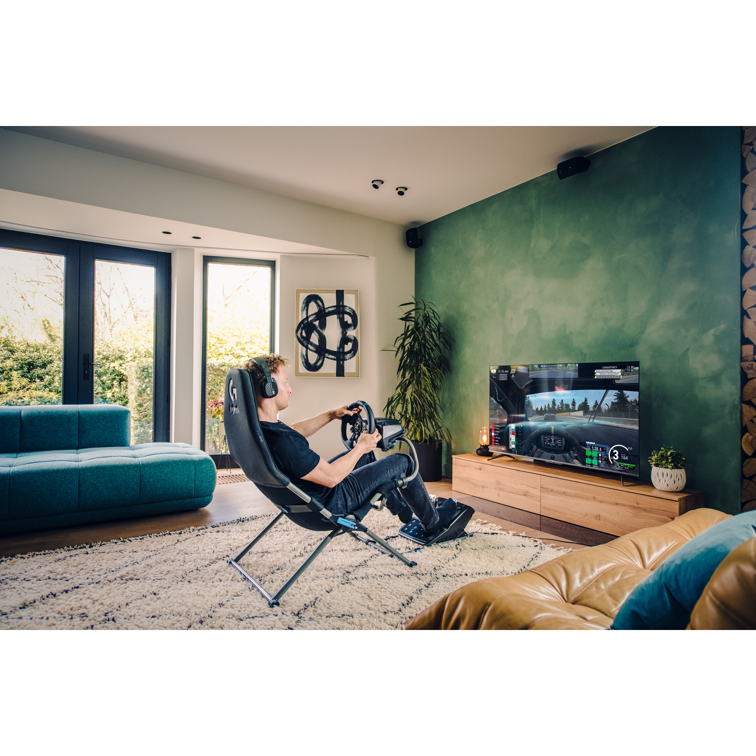 Een man met een koptelefoon speelt een racegame op een grote tv, zittend in een gamestoel met een stuurwiel.