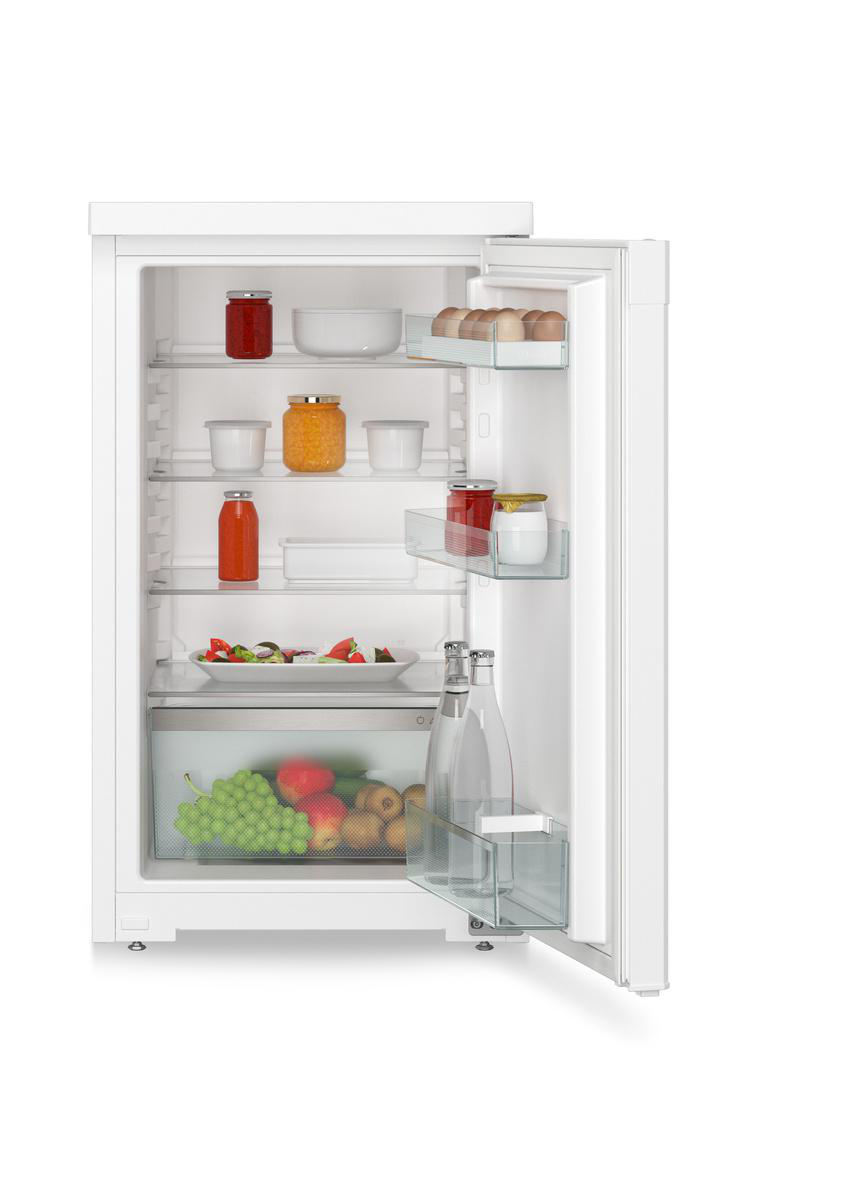 Offener weißer Kühlschrank mit verschiedenen Lebensmitteln, darunter Gläser, Flaschen und Produkte.