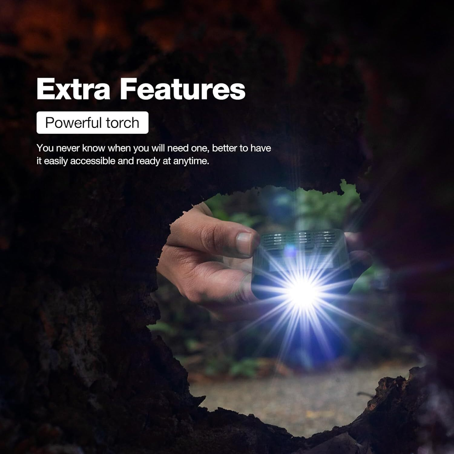 A hand holding a small flashlight with a bright light, surrounded by dark wood.