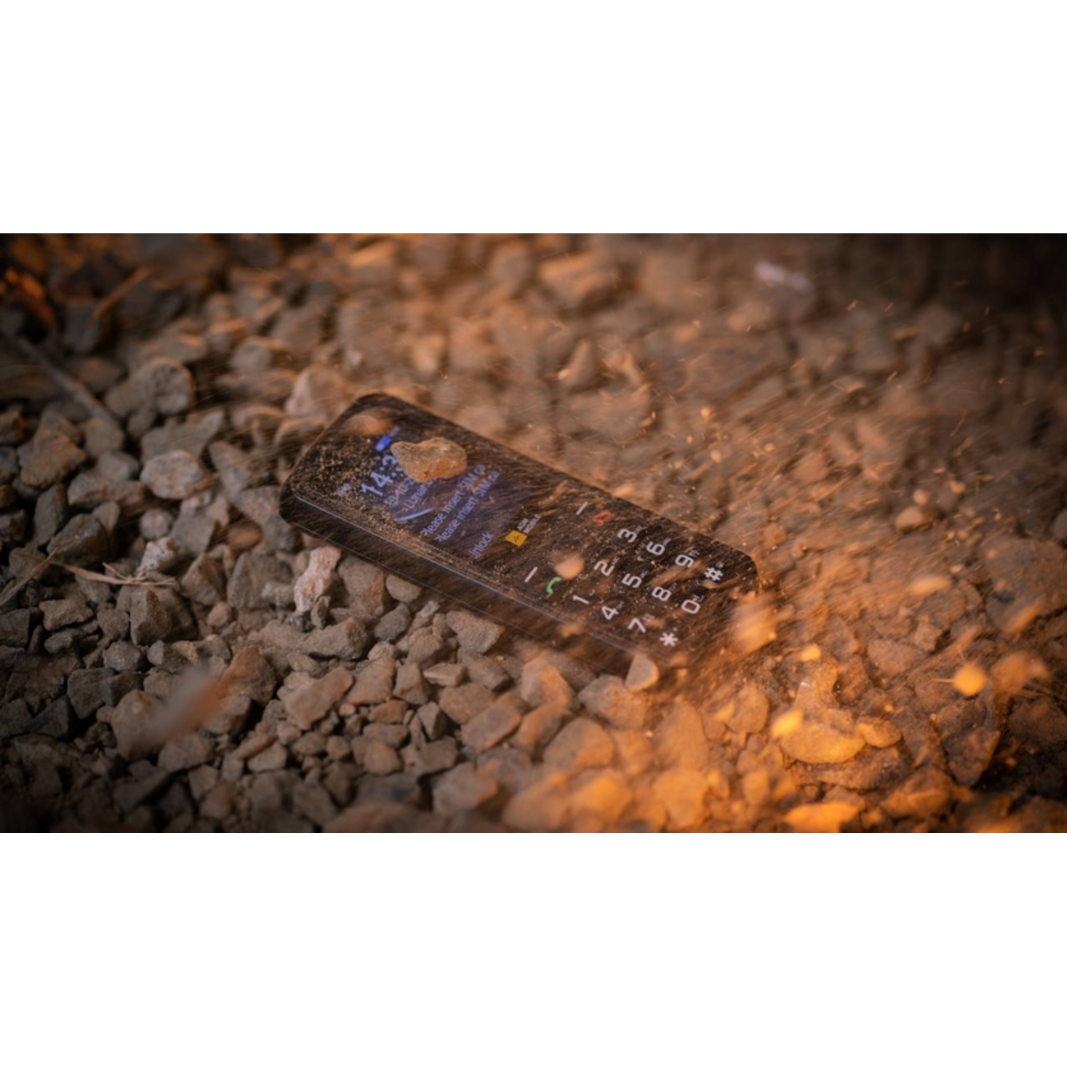 Black phone on rocks, water splash effect, screen on.