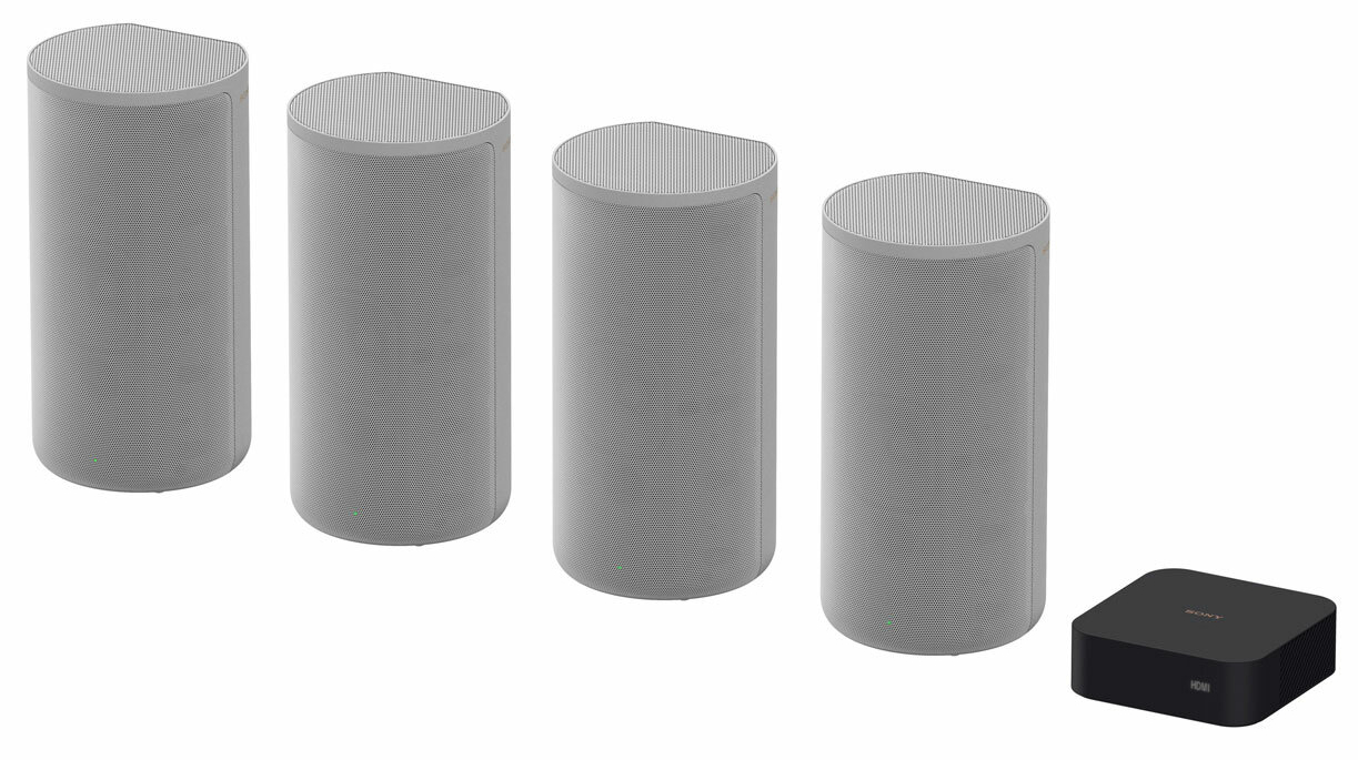 Cztery szare, cylindryczne głośniki i czarny box. Głośniki mają małe zielone światła.