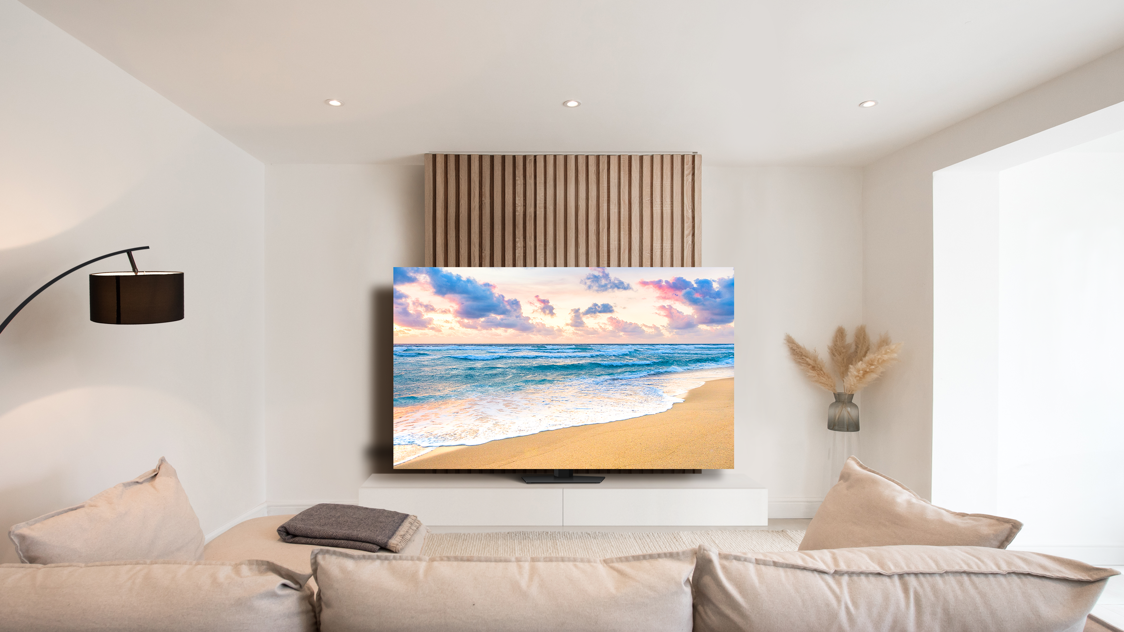 Ein Fernsehbildschirm mit einer Strandszene, in einem Wohnzimmer in neutralen Tönen.