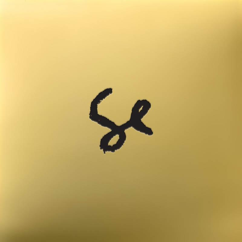 Ein schwarzer, handschriftlicher Buchstabe 'se' auf einem goldenen Hintergrund.