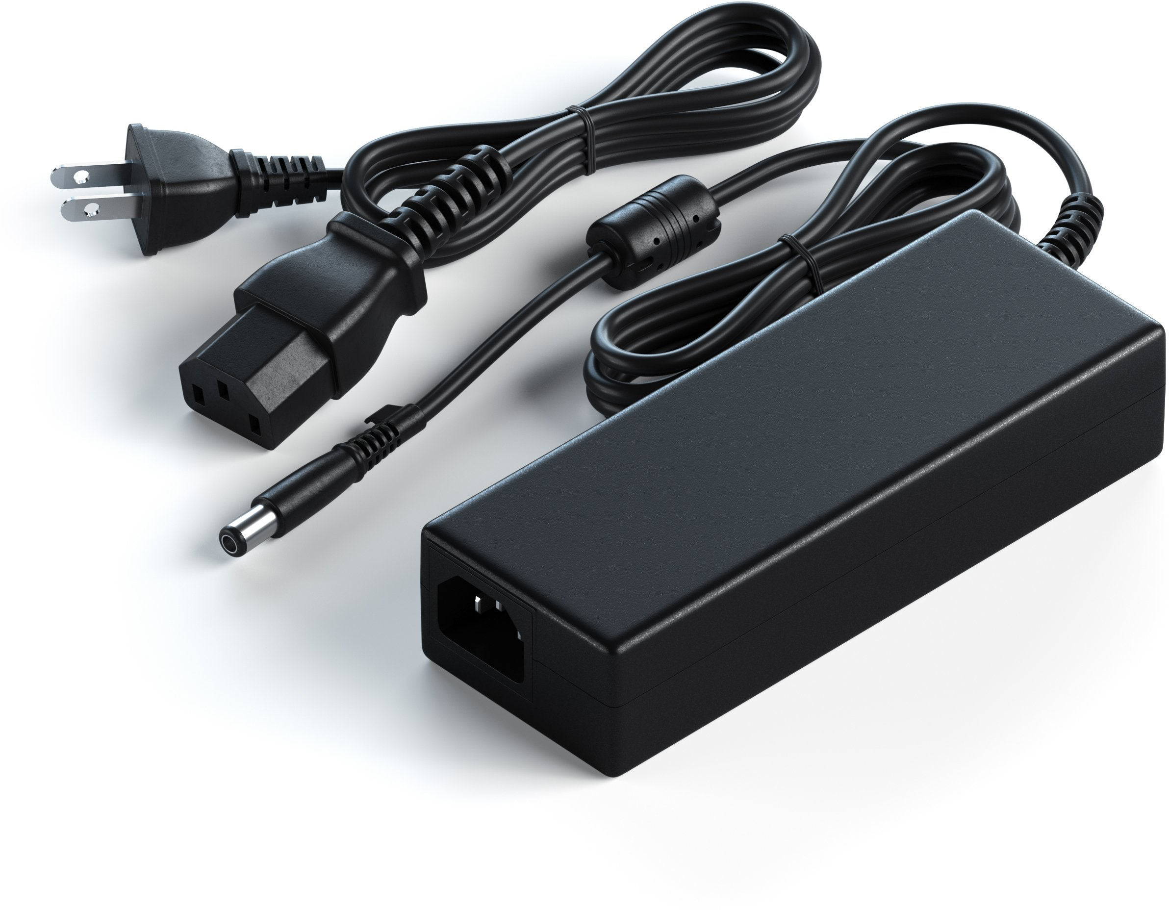 Fekete tápegység kábelekkel és dugókkal. Fehér háttér. Elektromos alkatrészek.