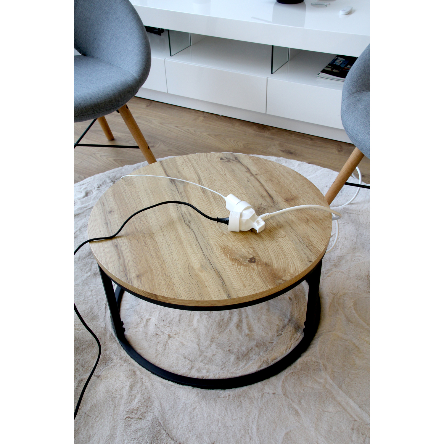 Table ronde en bois avec câbles et une multiprise.