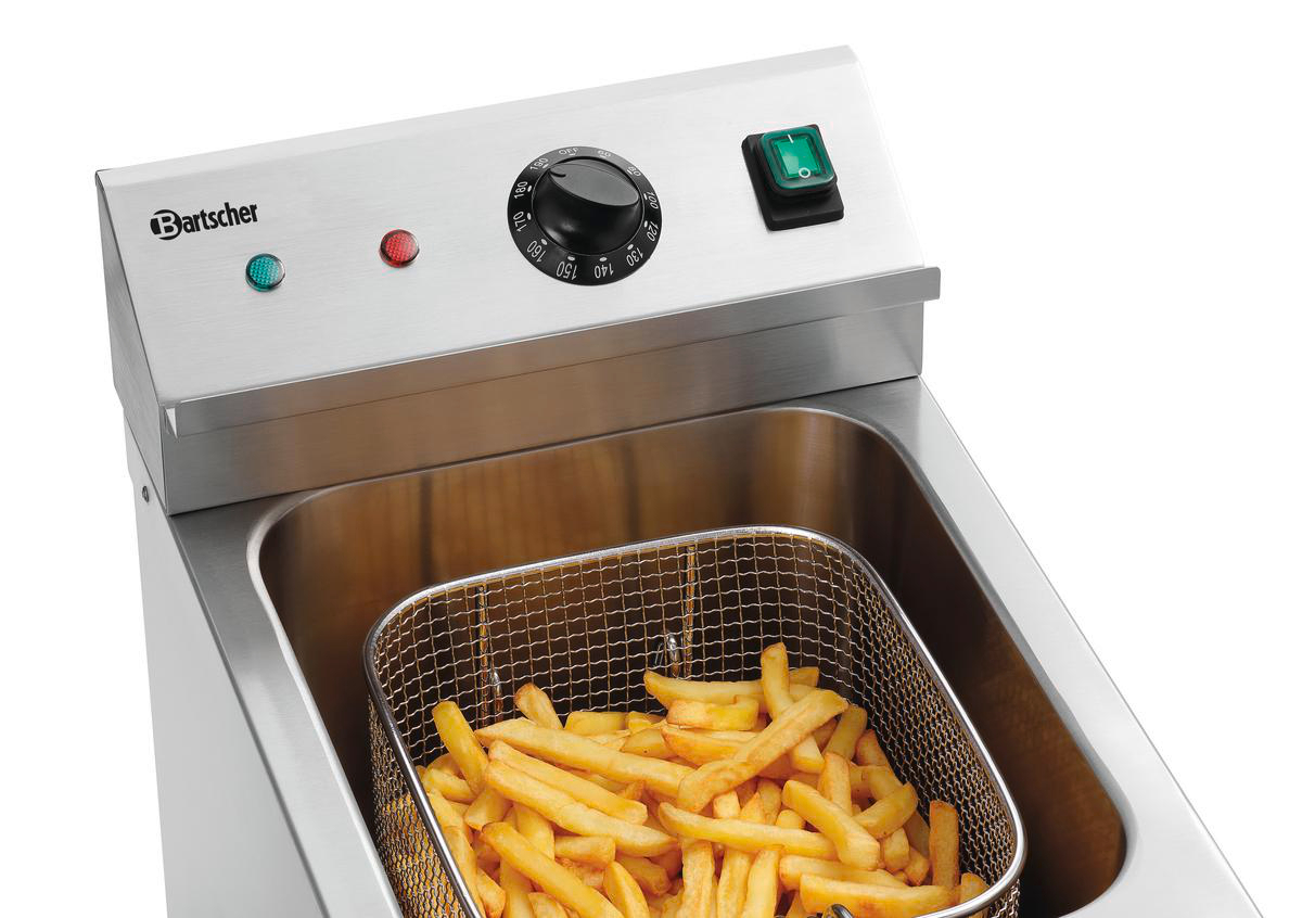 Edelstahlfritteuse mit einem Metallkorb voller goldener Pommes Frites.