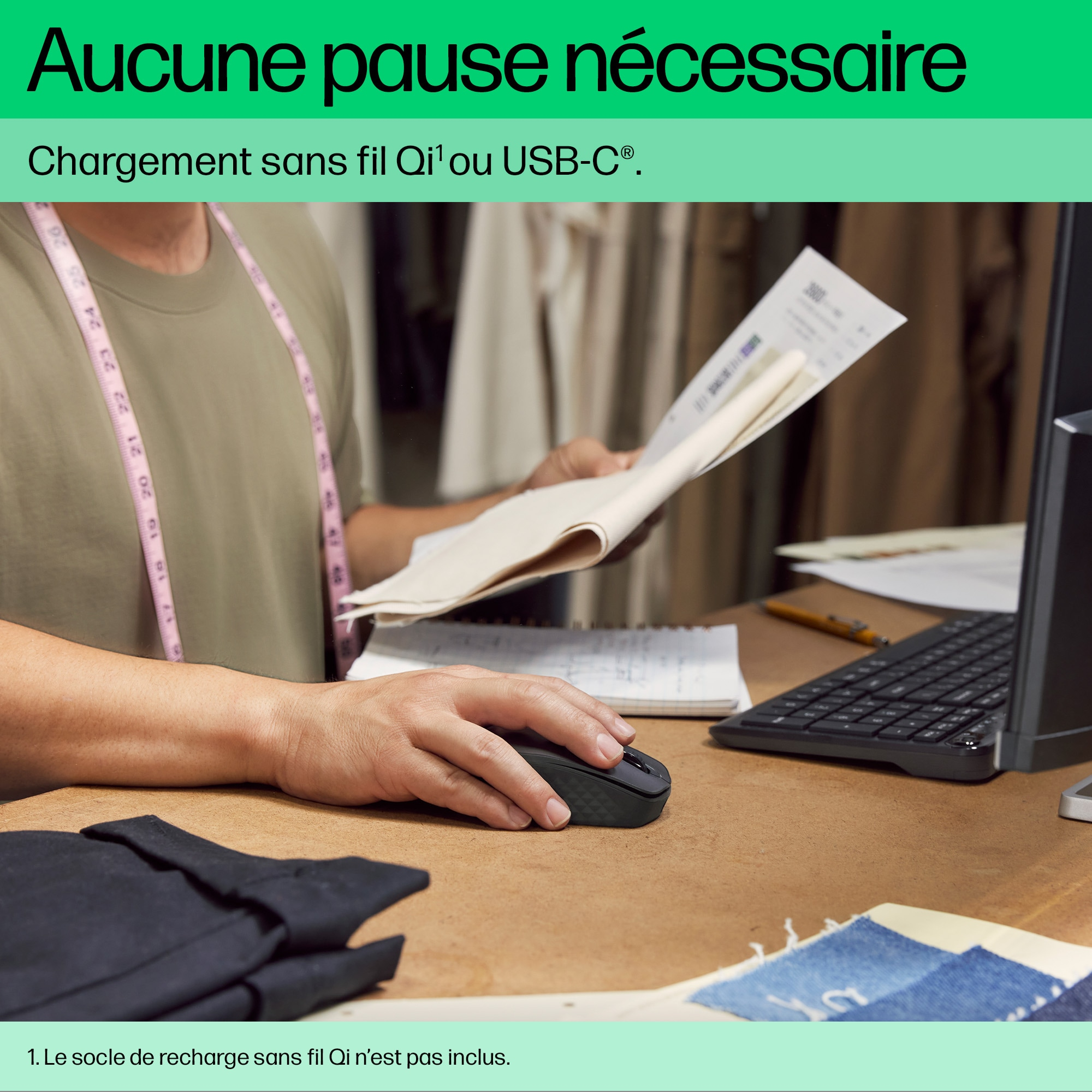 Une personne utilise une souris près d'un clavier d'ordinateur et des papiers sur un bureau en bois brun.