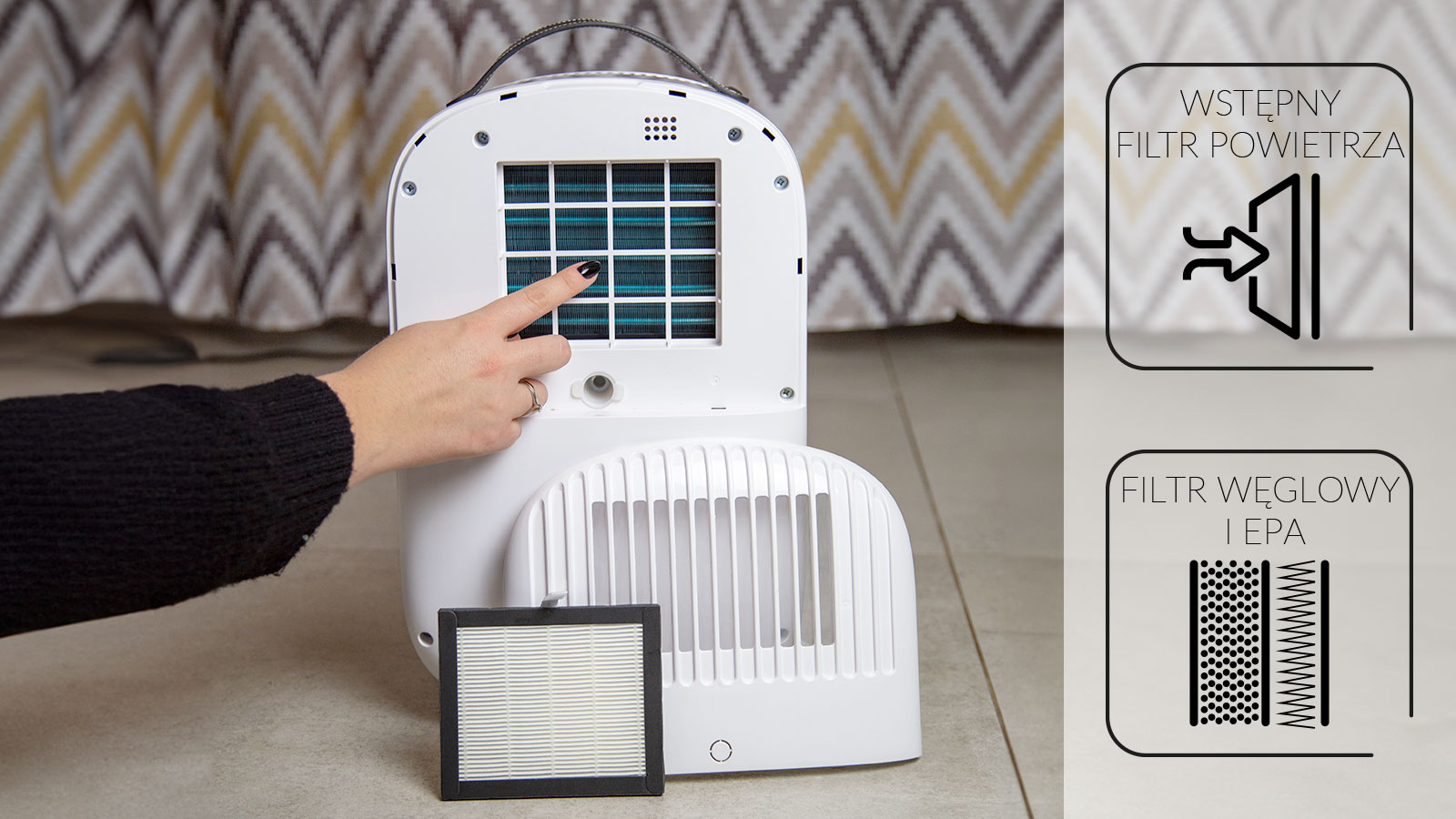Ręka wskazuje na filtr wewnątrz białego oczyszczacza powietrza.
