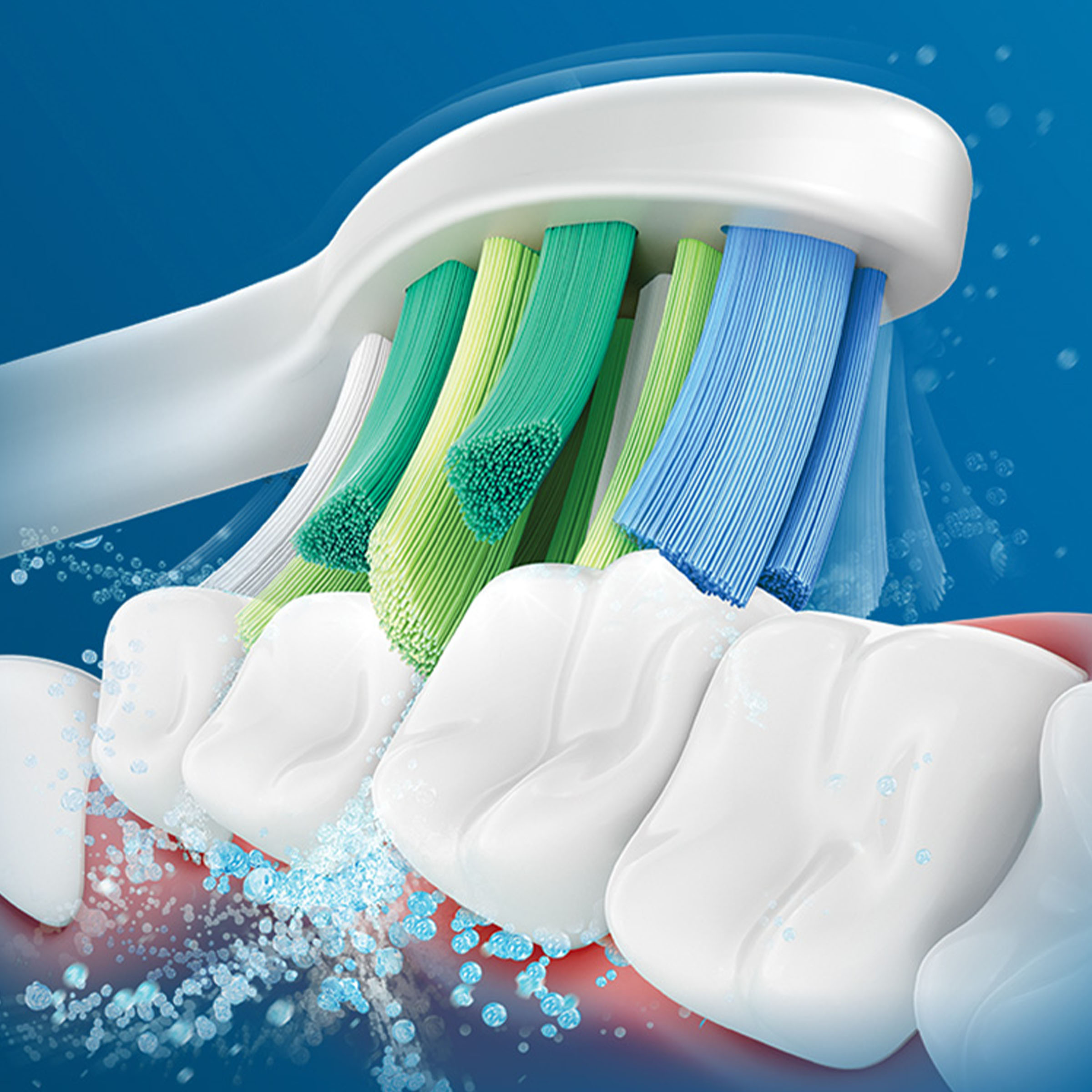 Zbliżenie na włosie szczoteczki i zęby. Niebieskie i zielone włosie czyszczące. Widoczne bąbelki.