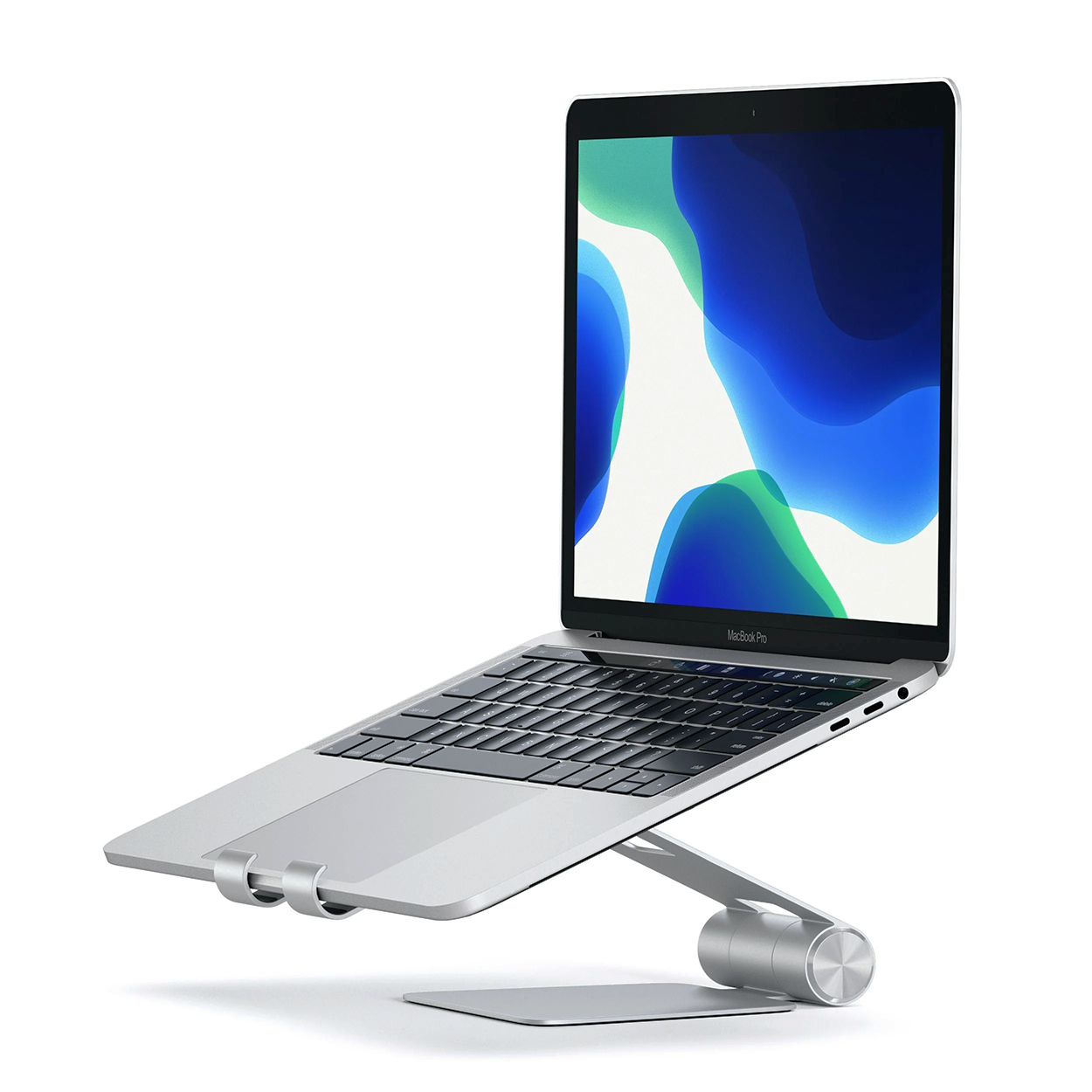 Ezüst laptop ezüst állványon. A képernyő nyitva van, és színes háttérképet mutat.