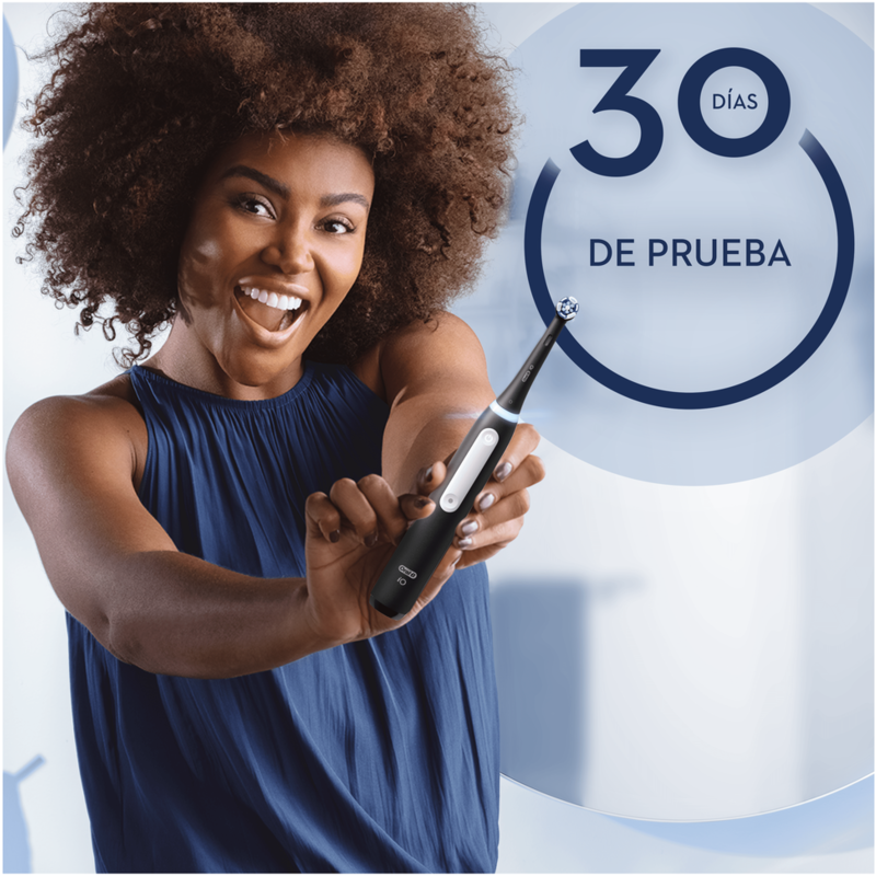 Mujer sonriente sosteniendo un cepillo de dientes eléctrico negro.