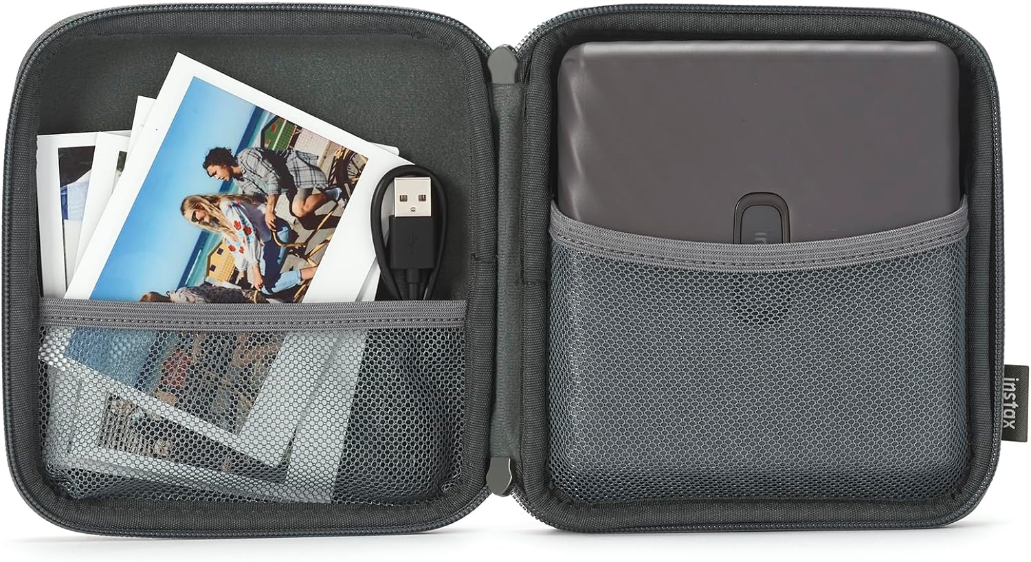 Estuche gris abierto con una impresora, fotos Instax, un cable USB y un bolsillo de malla, sobre fondo blanco.