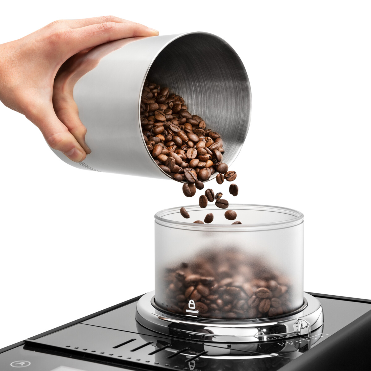 A person is pouring coffee beans from a silver container into a grinder.