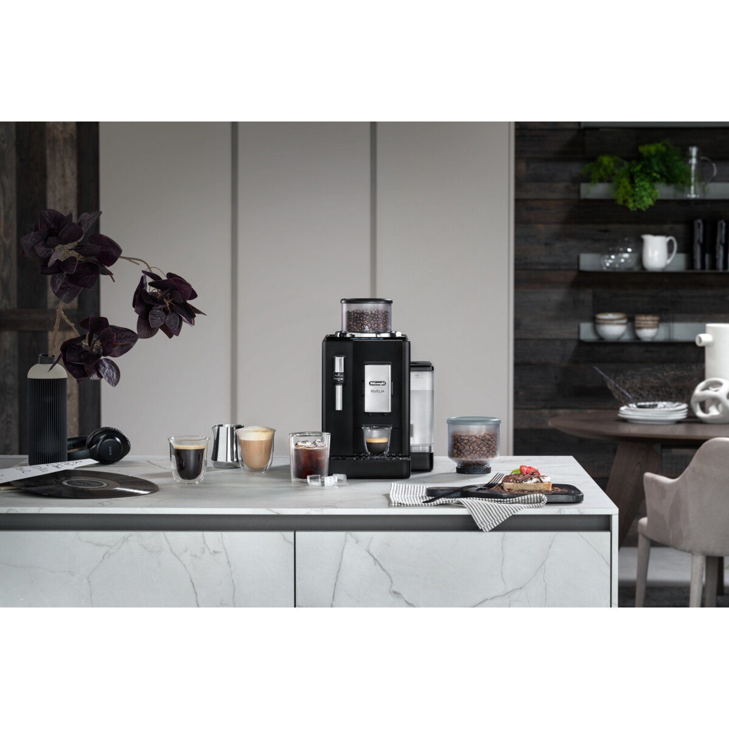 Keuken met koffiezetapparaat, glazen en eten op een aanrecht.