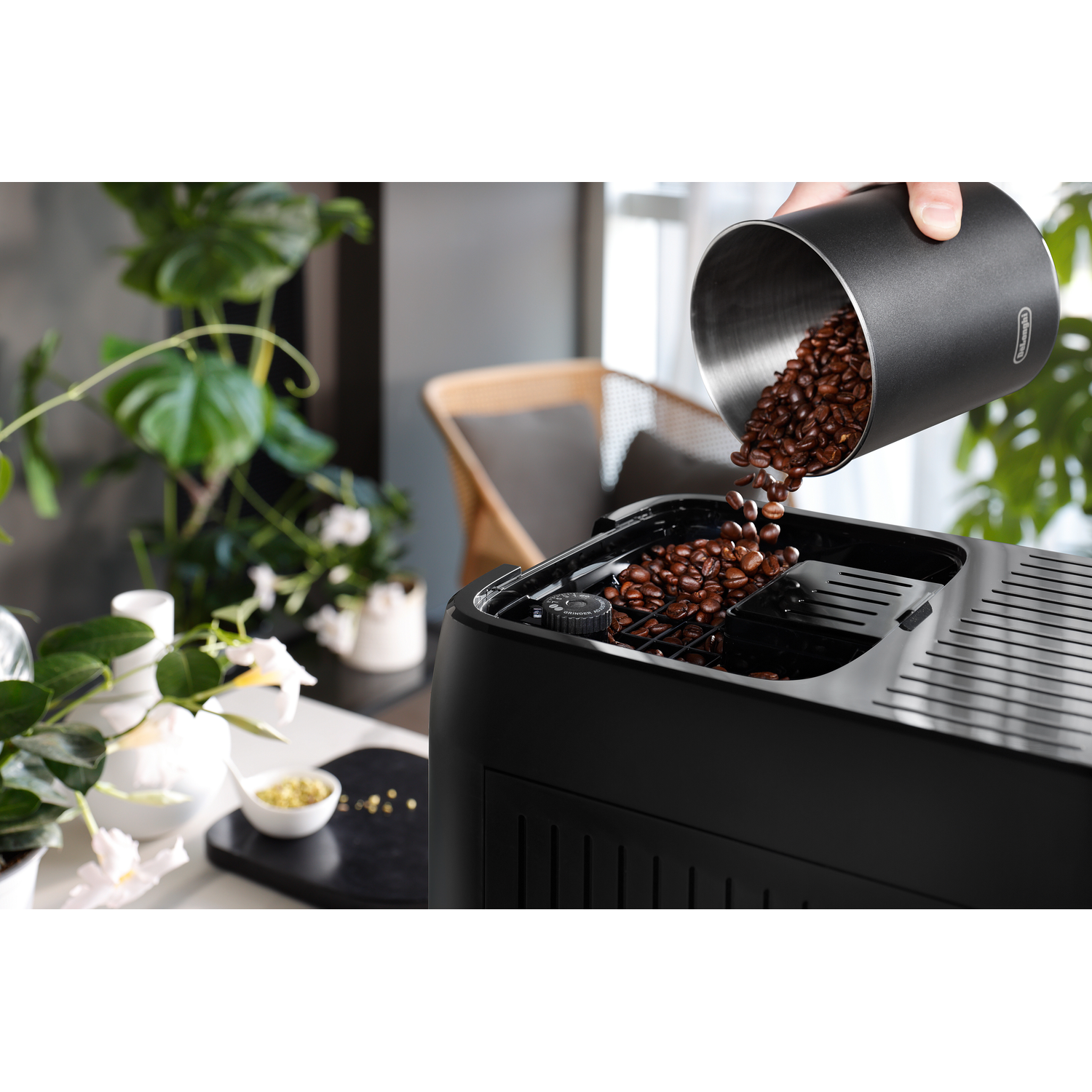 Koffiebonen worden in een zwarte koffiemachine gegoten.