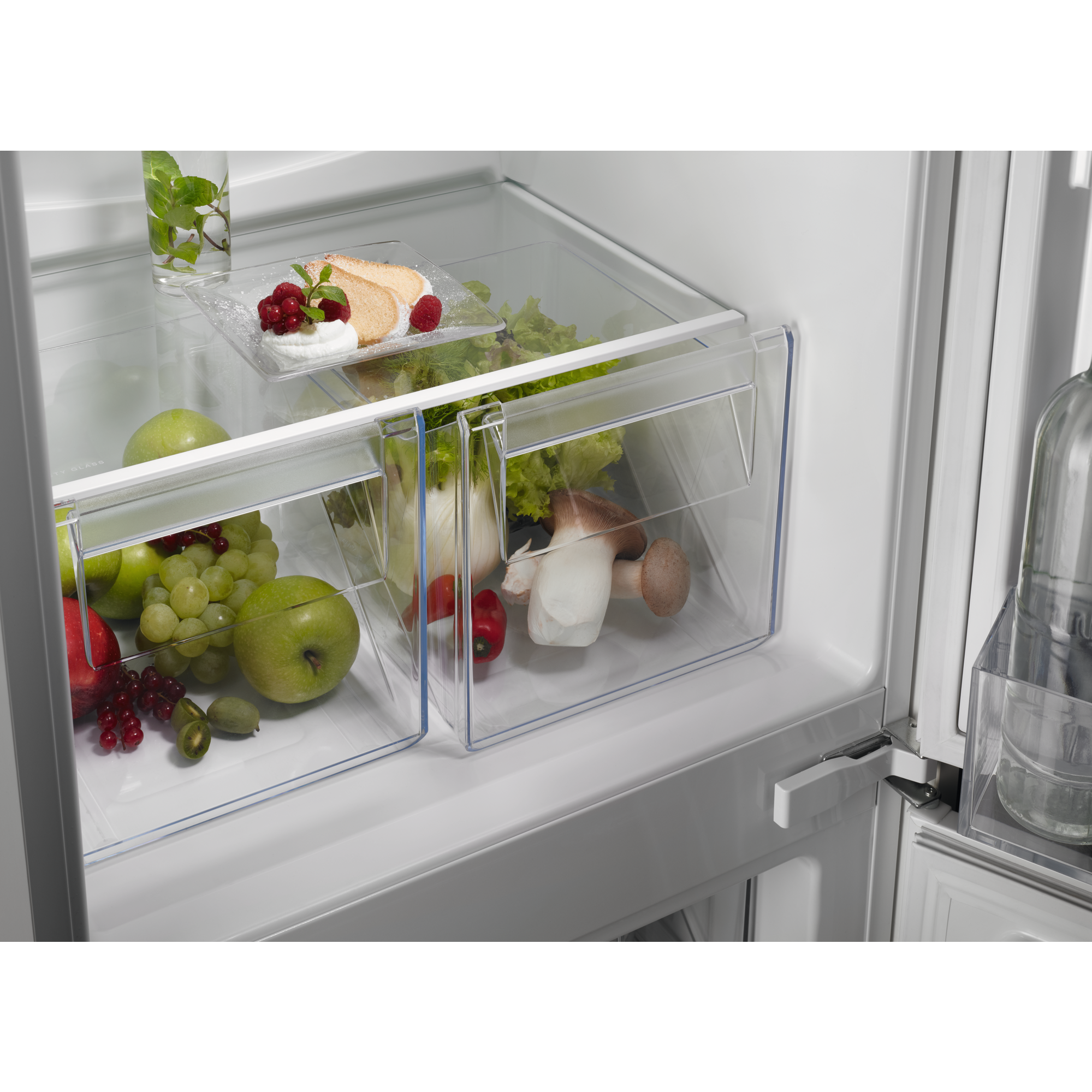 Im Kühlschrank halten klare Schubladen Lebensmittel wie Obst, Gemüse und Kuchen.