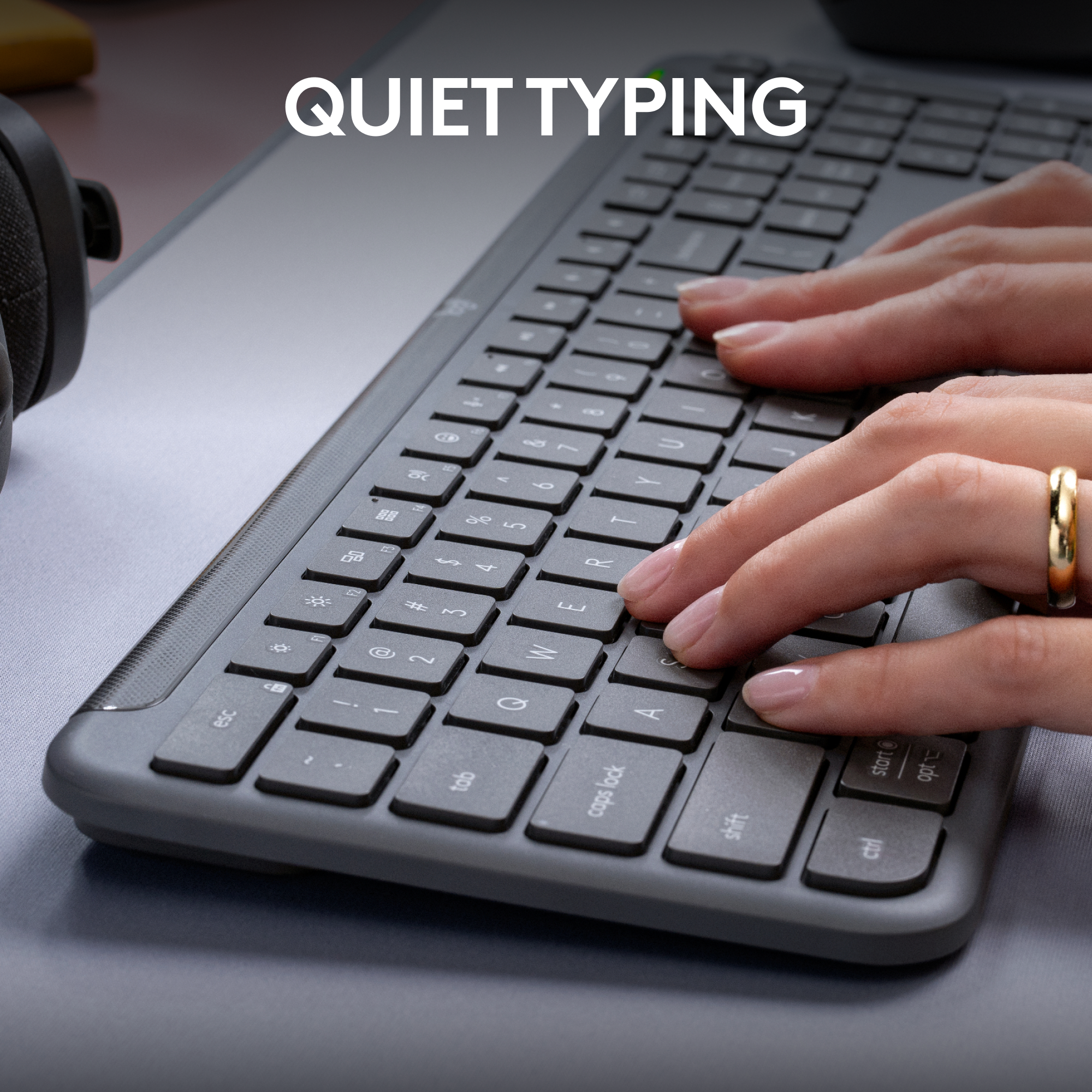 Mani su una tastiera scura, che digitano. In alto: 'QUIET TYPING'.