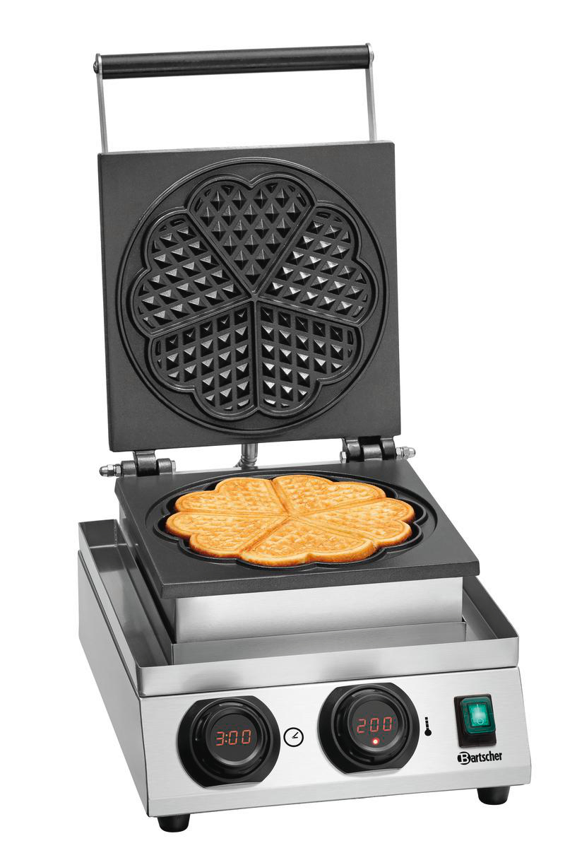 Ein Waffeleisen mit einem fertigen, herzförmigen Waffel.