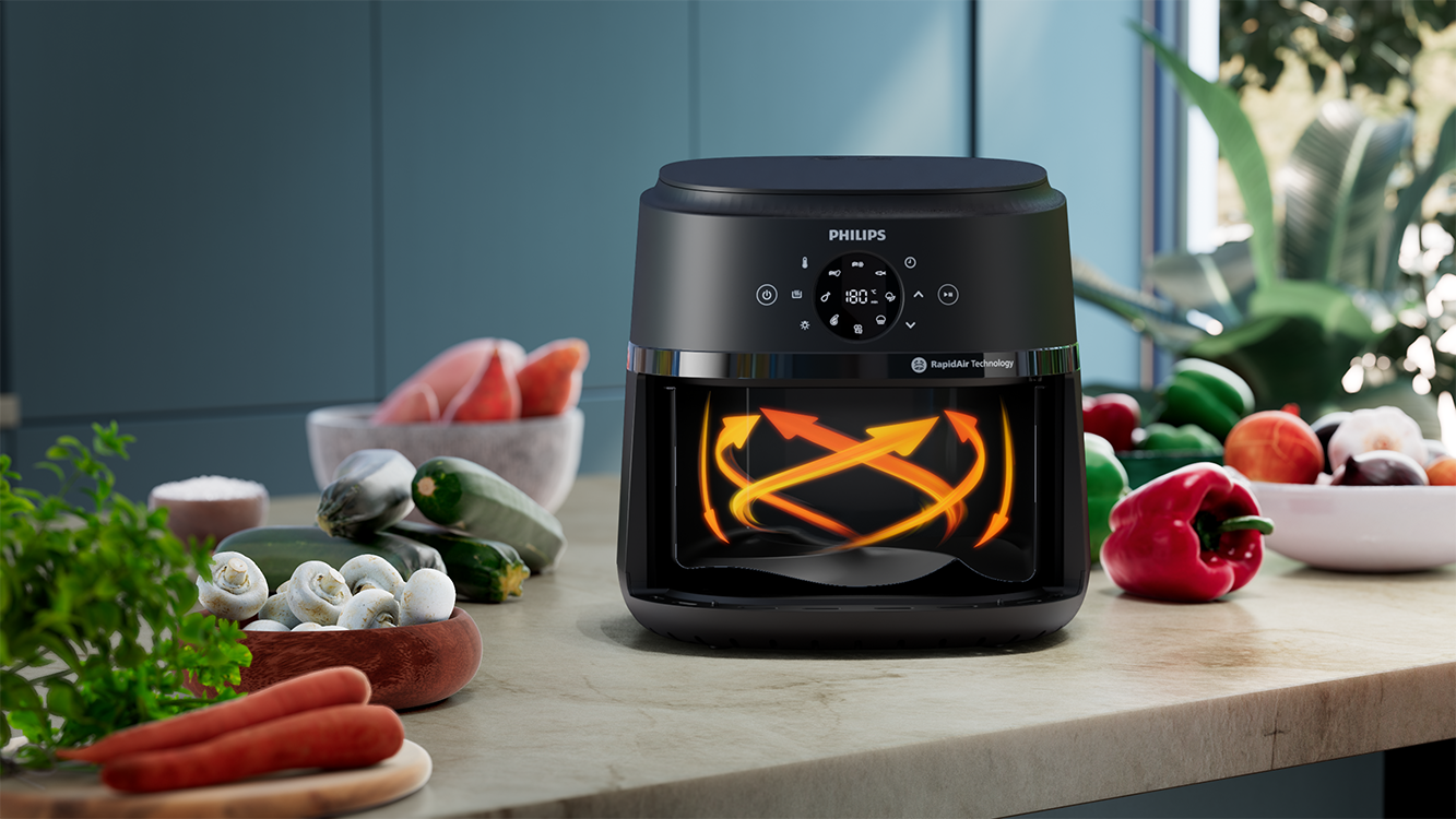 Egy fekete Philips air fryer ételekkel a pulton.