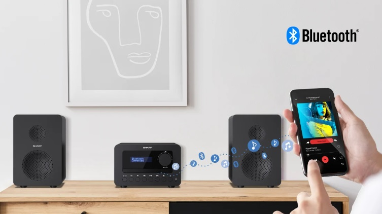 System audio w domu z dwoma głośnikami, odbiornikiem i smartfonem połączonym przez Bluetooth.
