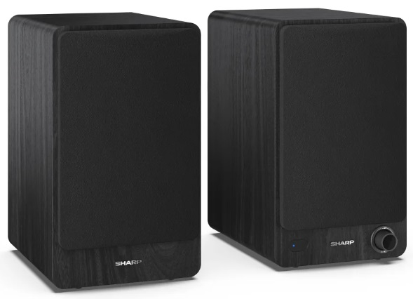 Dwa czarne głośniki z wykończeniem imitującym drewno. Lewy głośnik skierowany jest do widza.