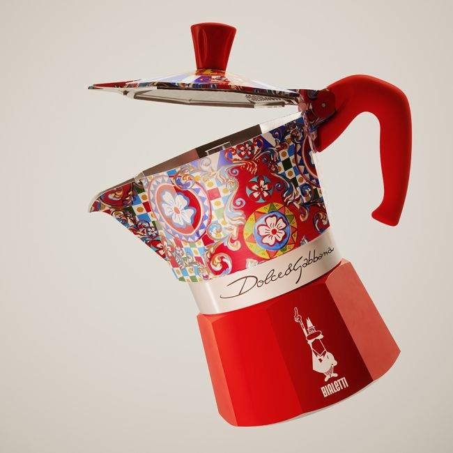 Ein rot und gemustert Dolce & Gabbana Espressokocher, mit geöffnetem Deckel, schwebend.