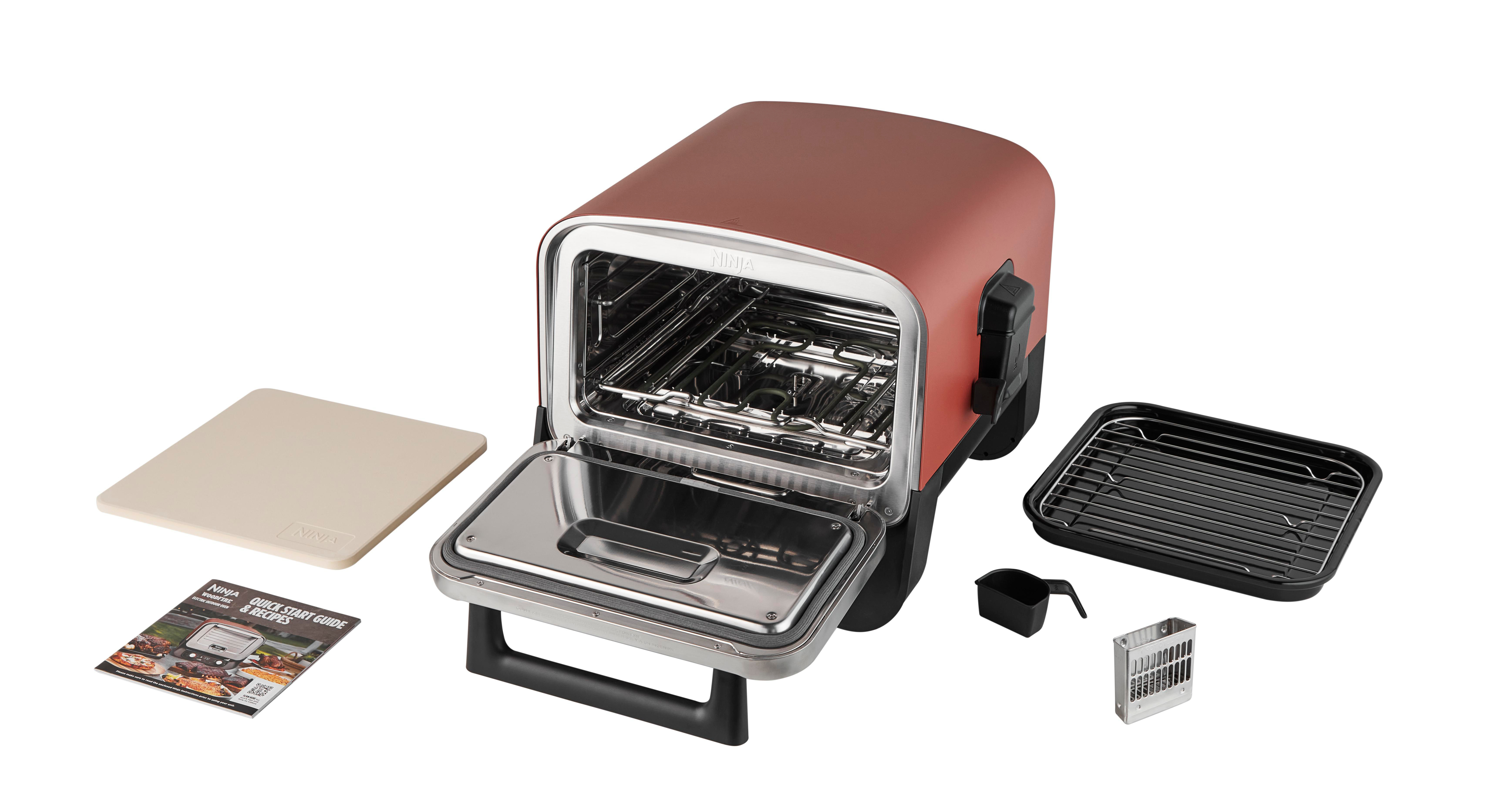 Ein offener roter Toaster-Ofen mit Zubehör. Der Hintergrund ist weiß.