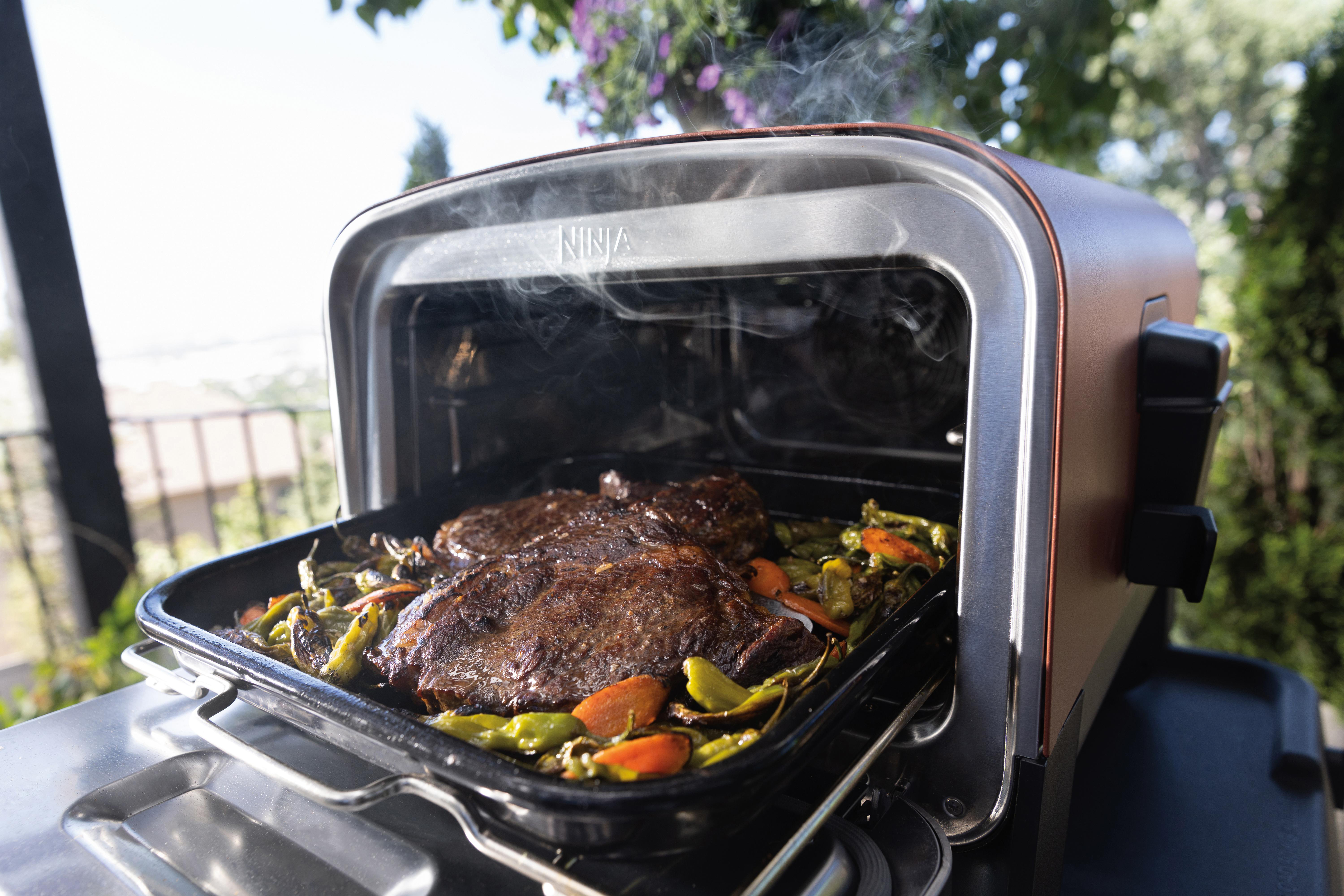 Ein offener Ninja-Heißluftfritteusen-Ofen mit gekochten Speisen im Inneren.