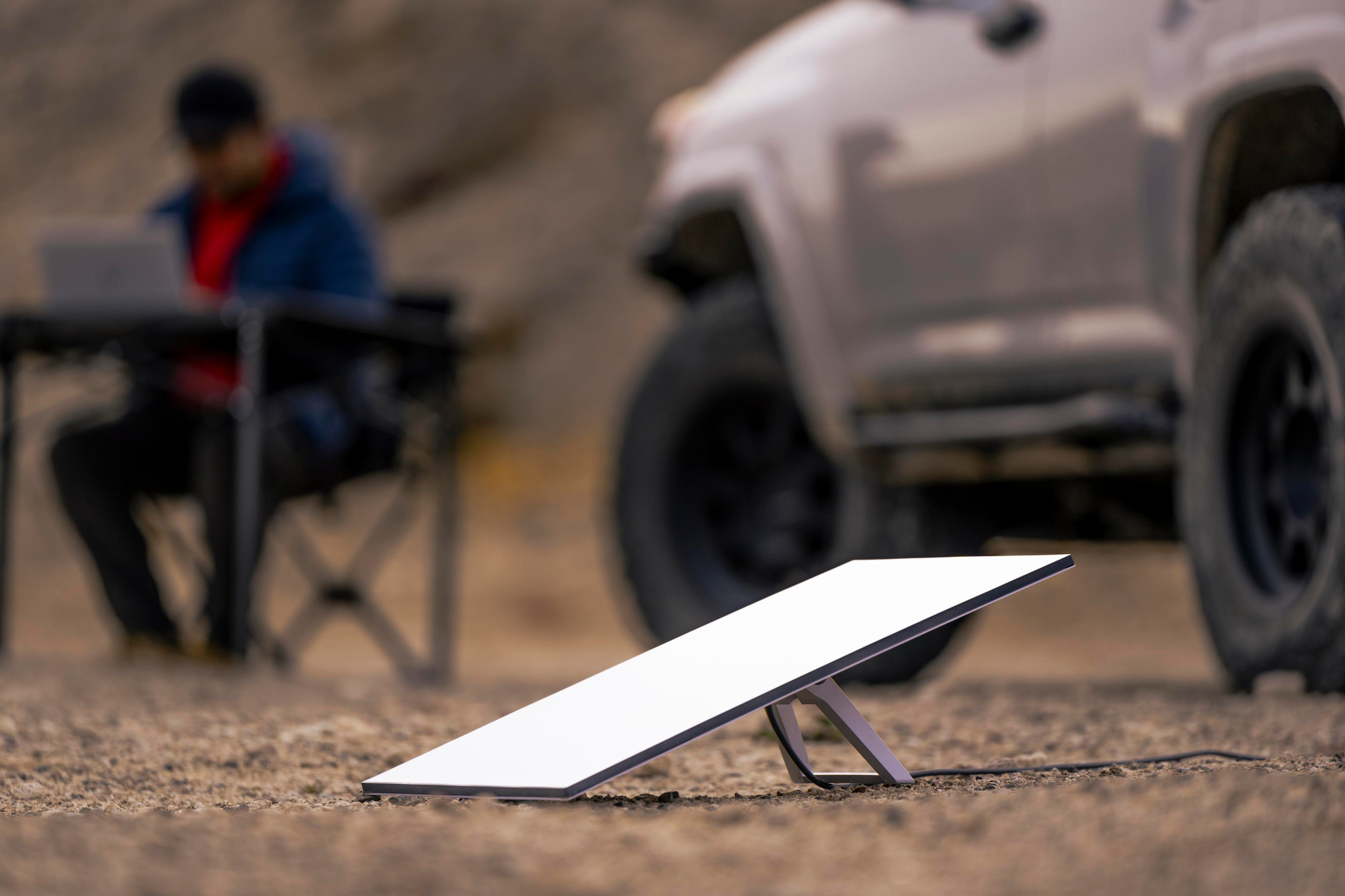 Ein Satelliten-Internet-Setup im Feld mit Person und Fahrzeug.