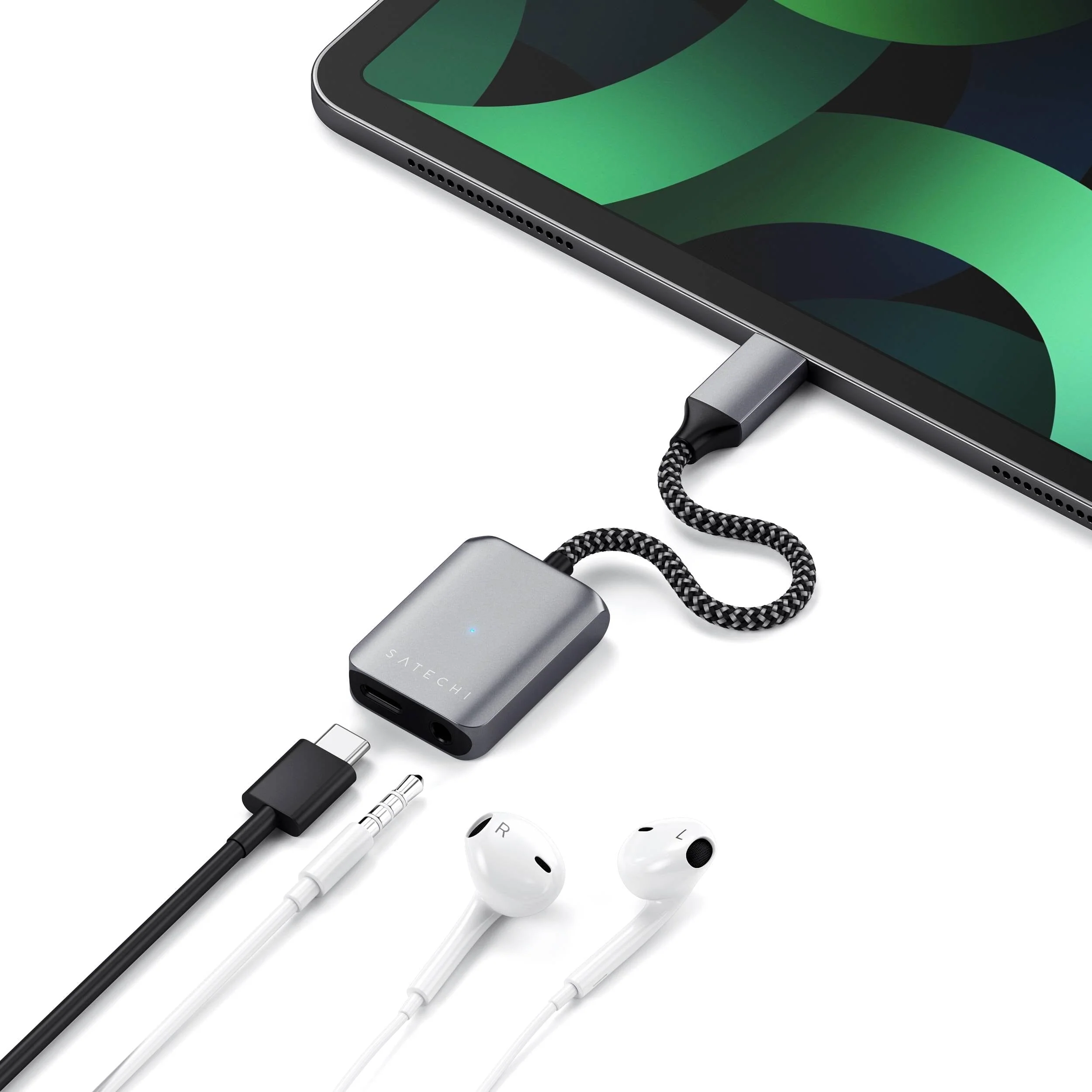 Ezüst USB-C adapter fehér kábellel és fehér fülhallgatóval.