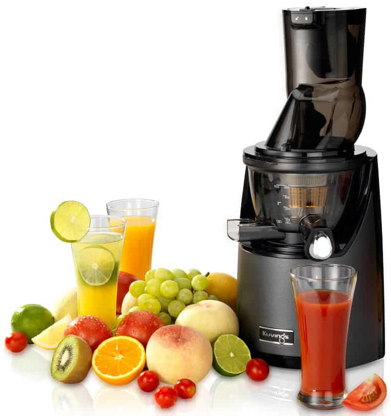 Wyciśnięta sokowirówka z różnymi owocami i szklankami soku na białym tle.