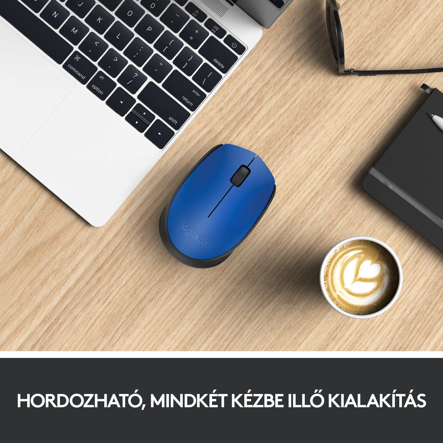 Egy kék Logitech egér egy fa asztalon egy laptop, kávé és szemüveg mellett.
