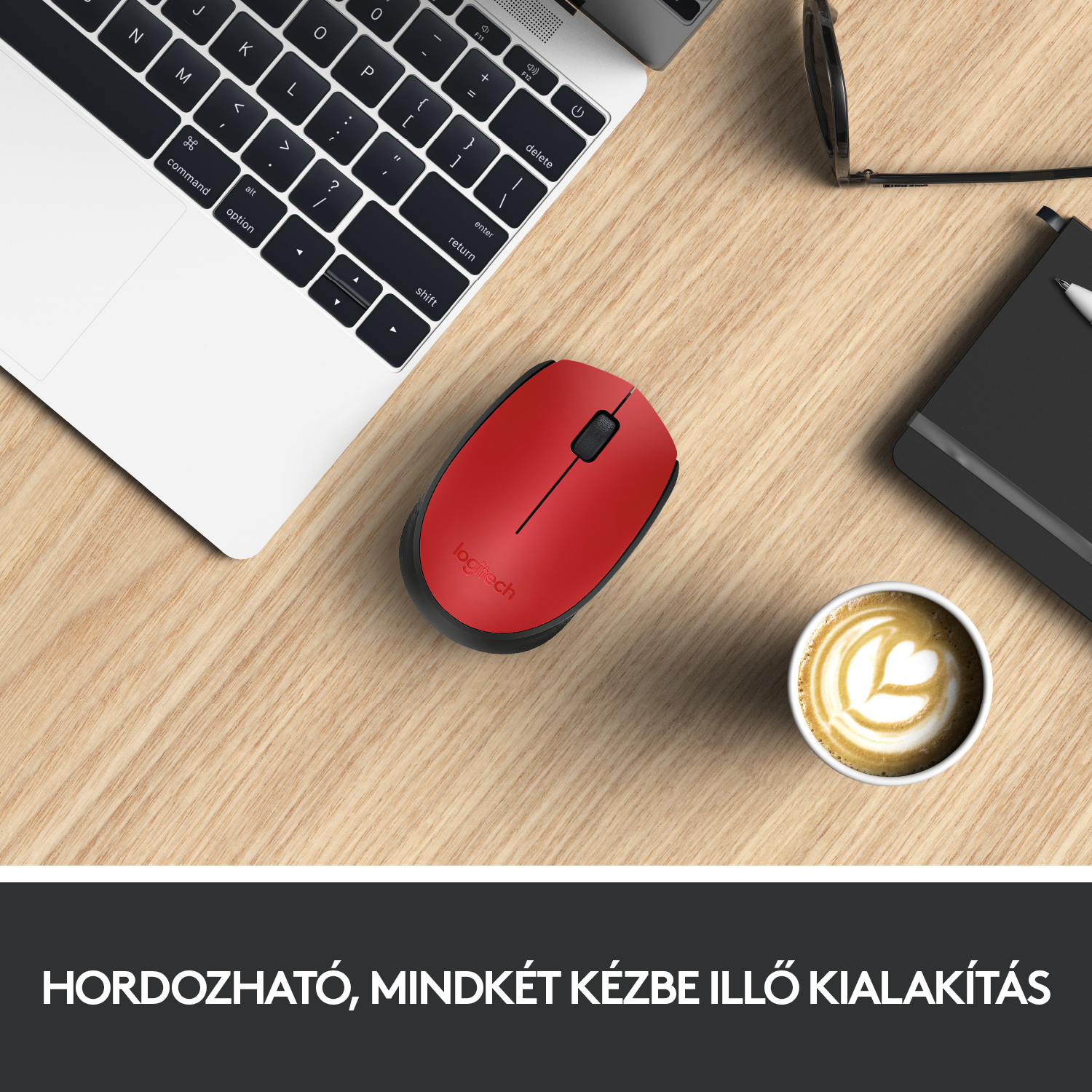 Piros Logitech egér fa asztalon, laptop és kávé közelében.