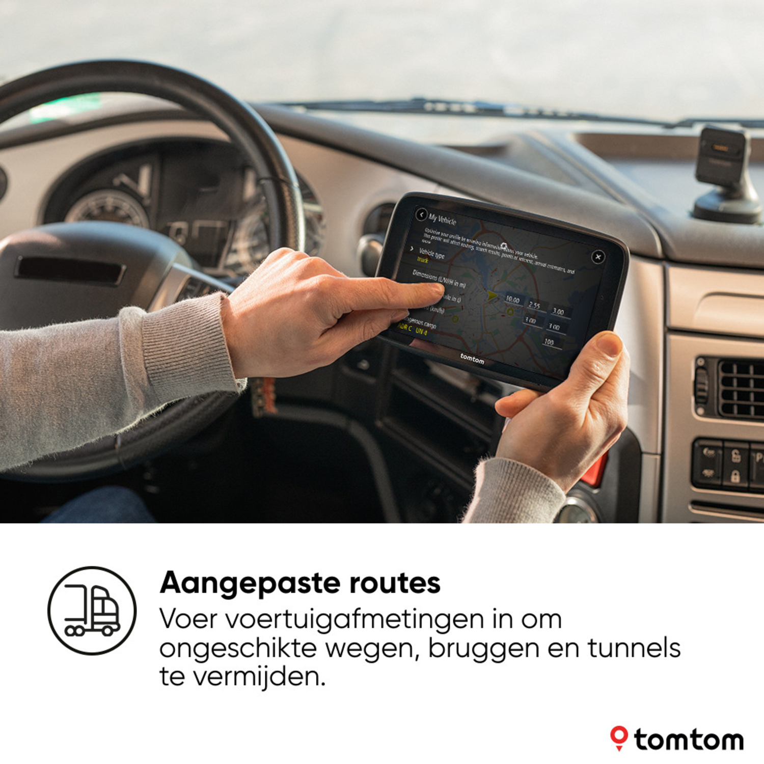 Person using a TomTom navigation device inside a truck. Shows a map.