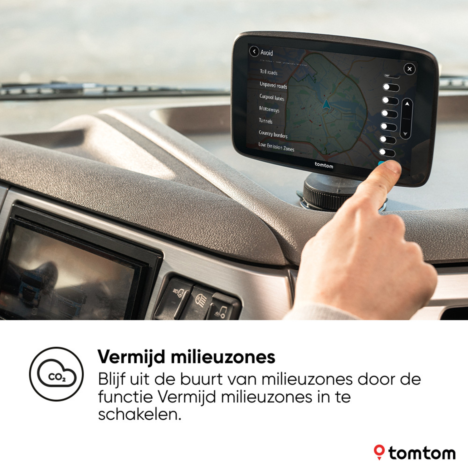 A hand touching a GPS navigation device. Text says 'Avoid Low Emission Zones'.