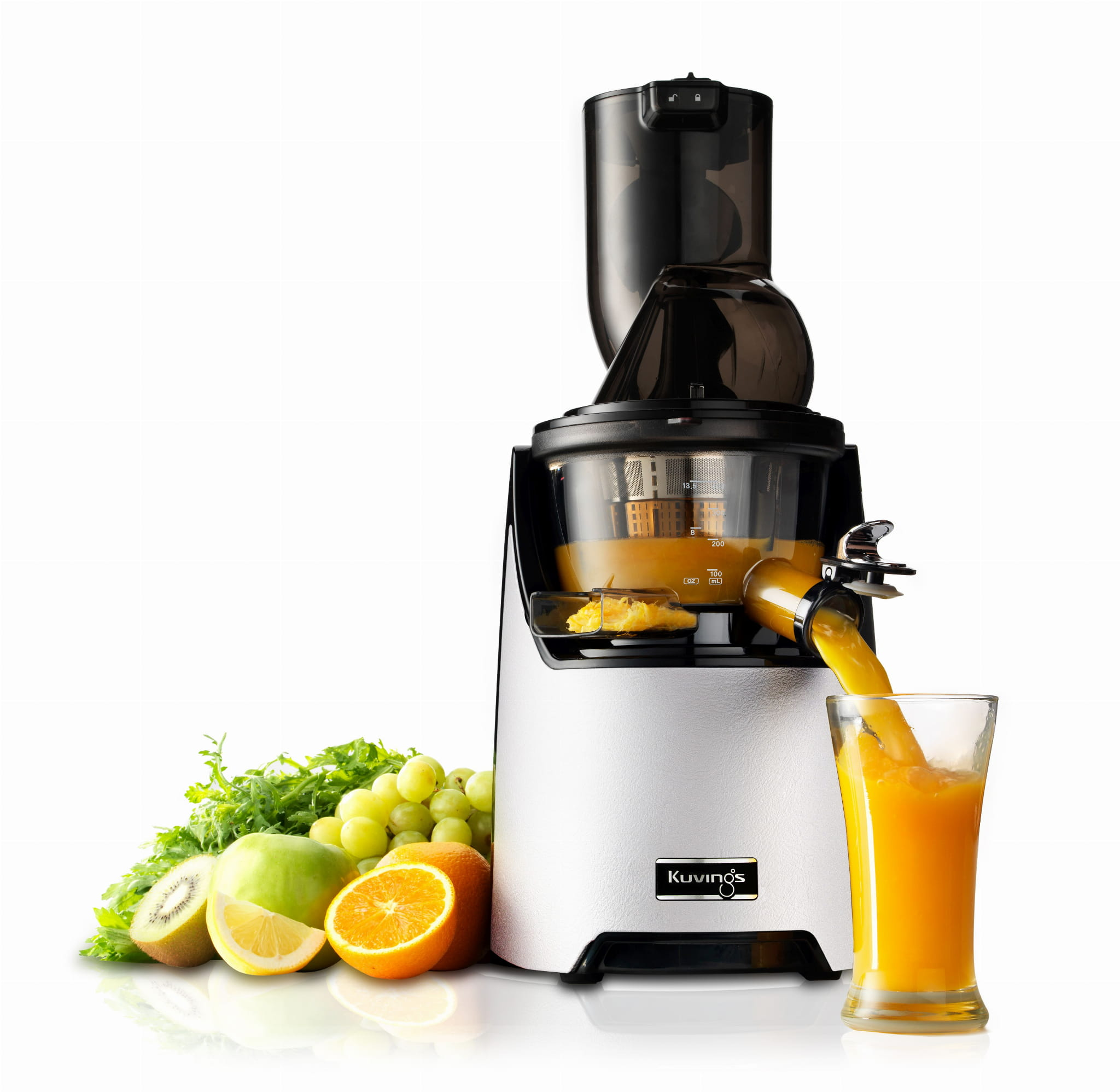 Wyciągarka do soku z sokiem wlewanym do szklanki, otoczona owocami i warzywami.