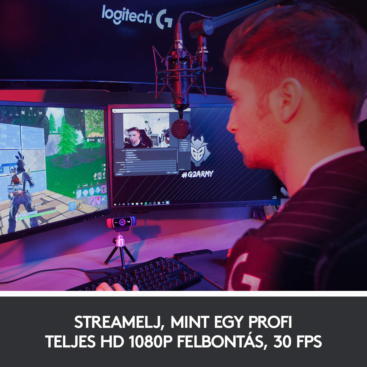 Egy személy két monitorral, mikrofonnal és billentyűzettel streamel.