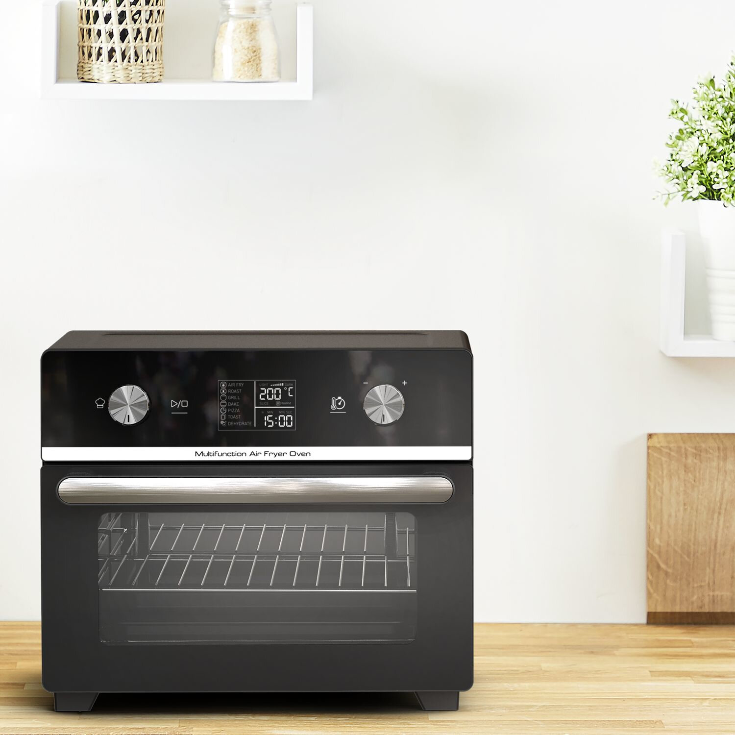 Un four friteuse à air noir avec écran est sur une surface en bois. Derrière, un mur blanc.
