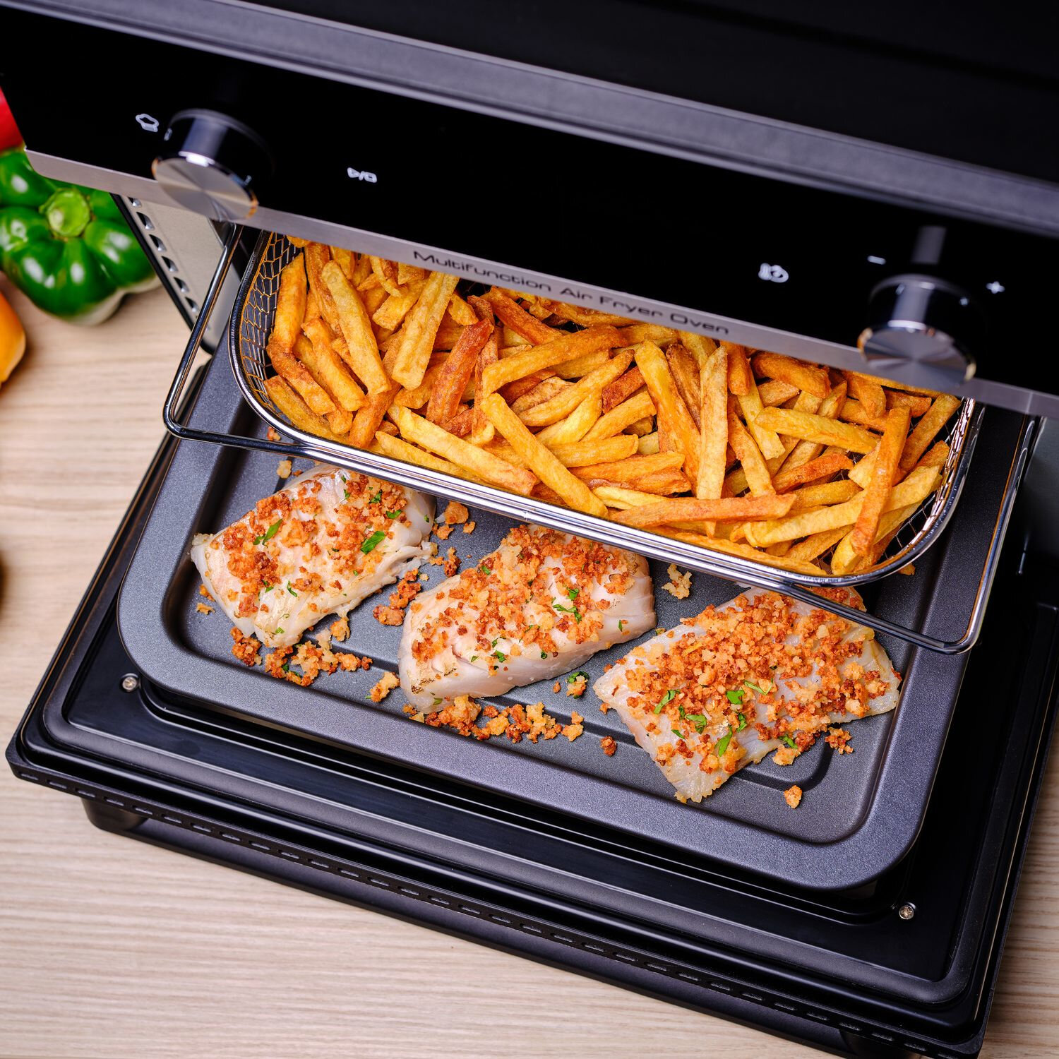 Four à air chaud avec frites et filets de poisson panés sur un plateau.