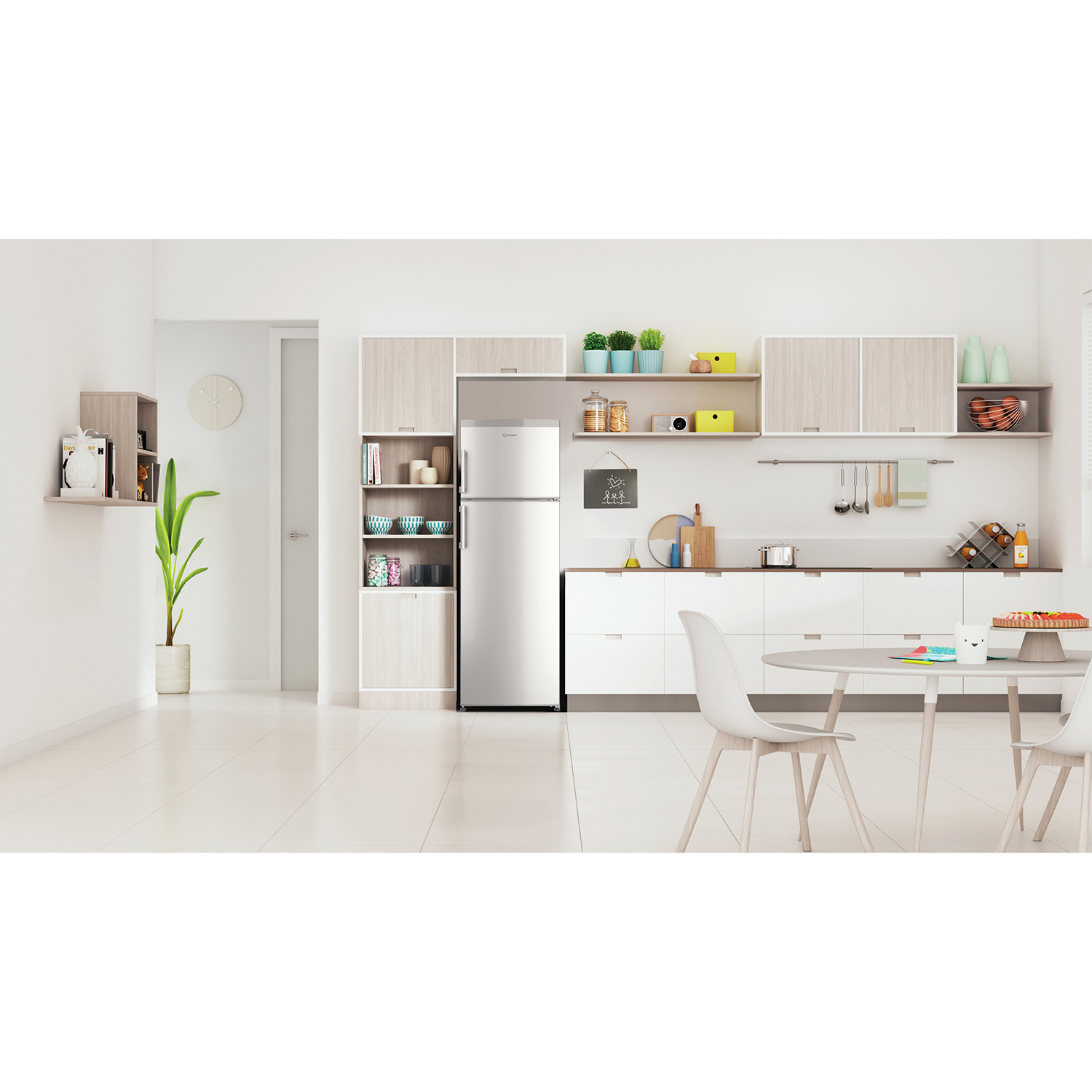 Cucina con mobili ed elettrodomestici bianchi. Frigorifero al centro. Un tavolo con sedie.