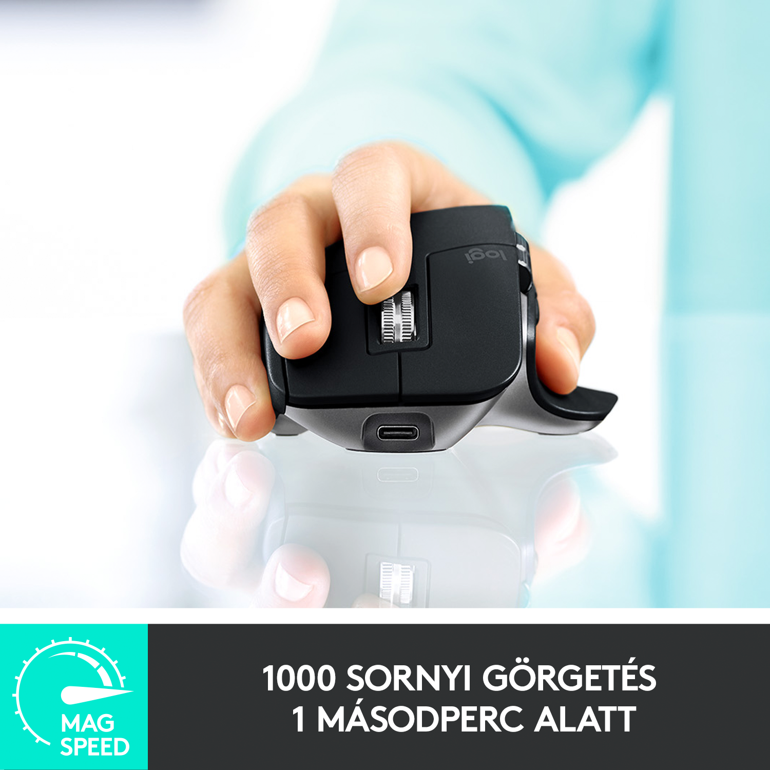 Személy keze fekete Logitech egeret tart, görgővel.
